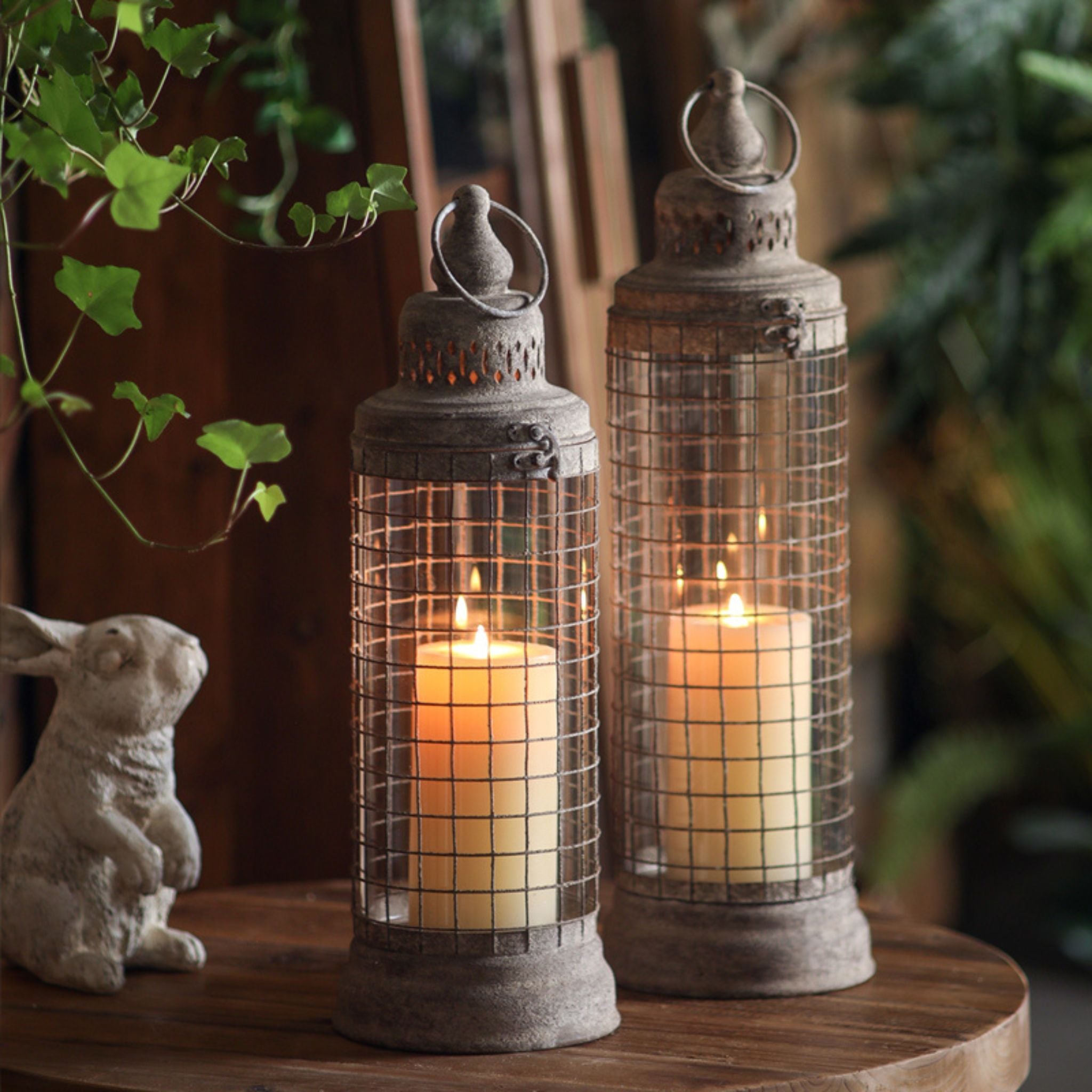 Elliott lantern, the taller on the right, shown beside its smaller matching size, both lit with pillar candles. Sold separately.