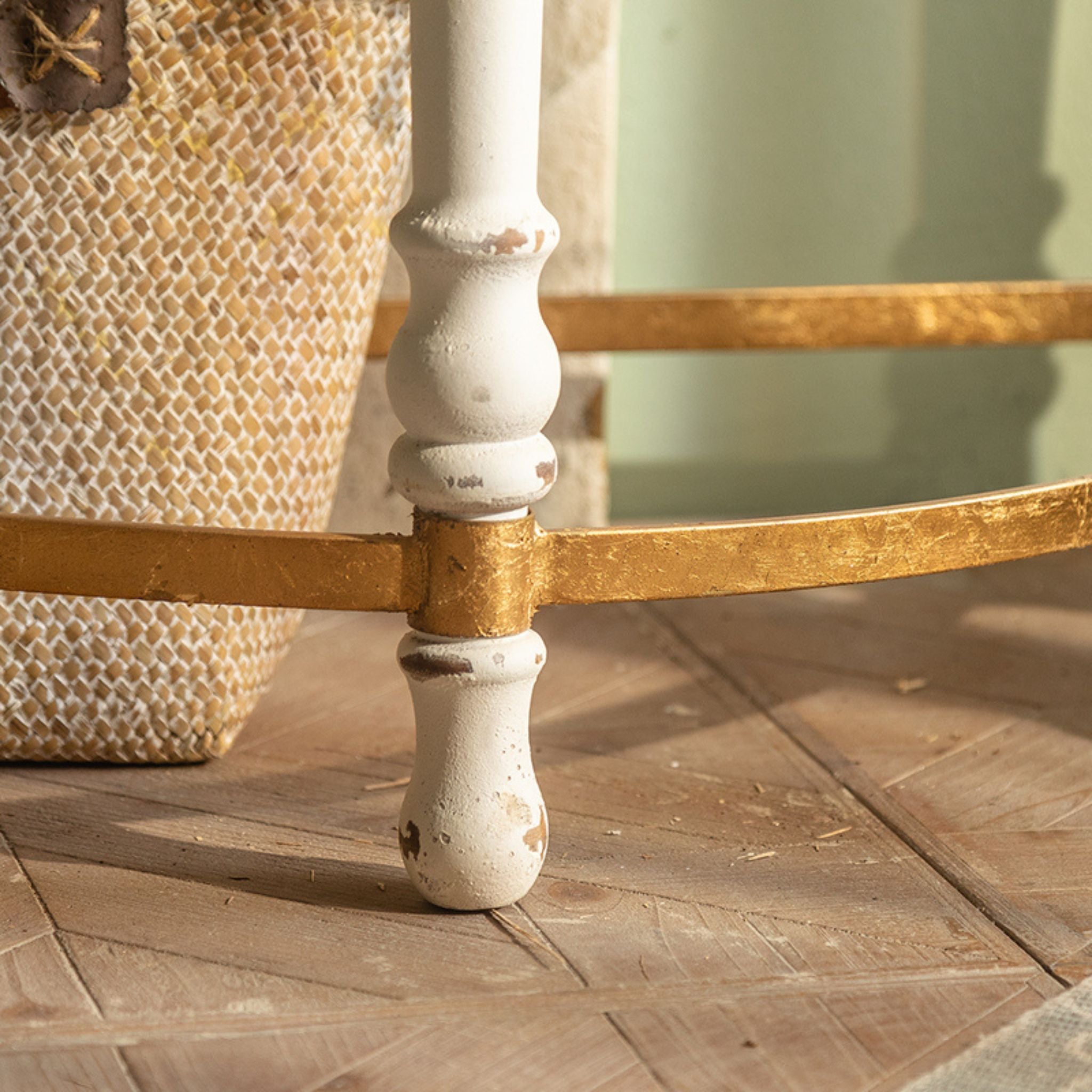 Detail of Estelle console's turned cream leg, chippy hand-finished paintwork and gold-leaf stretcher band where it joins the leg.