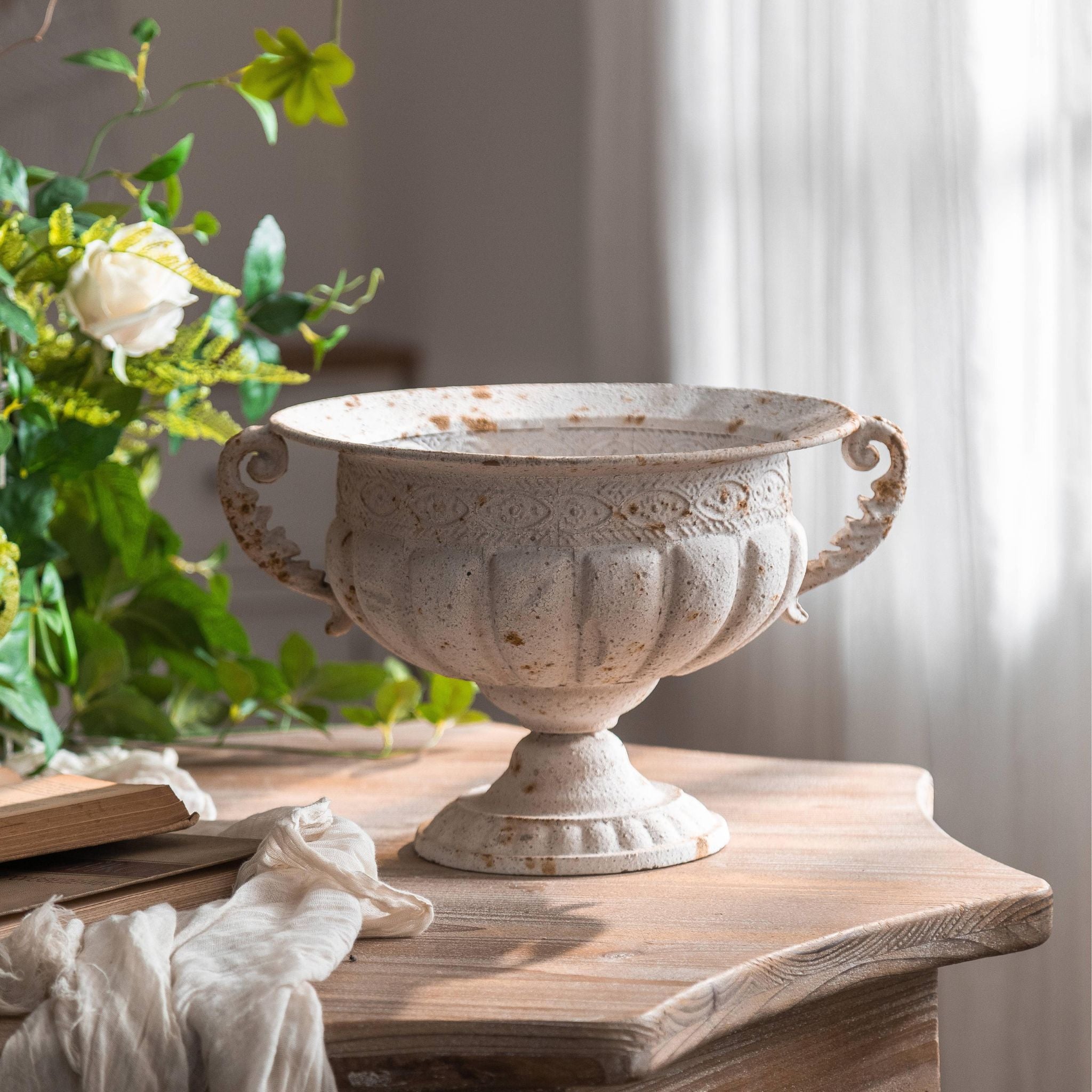 Fabien compote urn planter shown empty, twin scroll handles, gadrooned bowl and pedestal foot in distressed antique white.