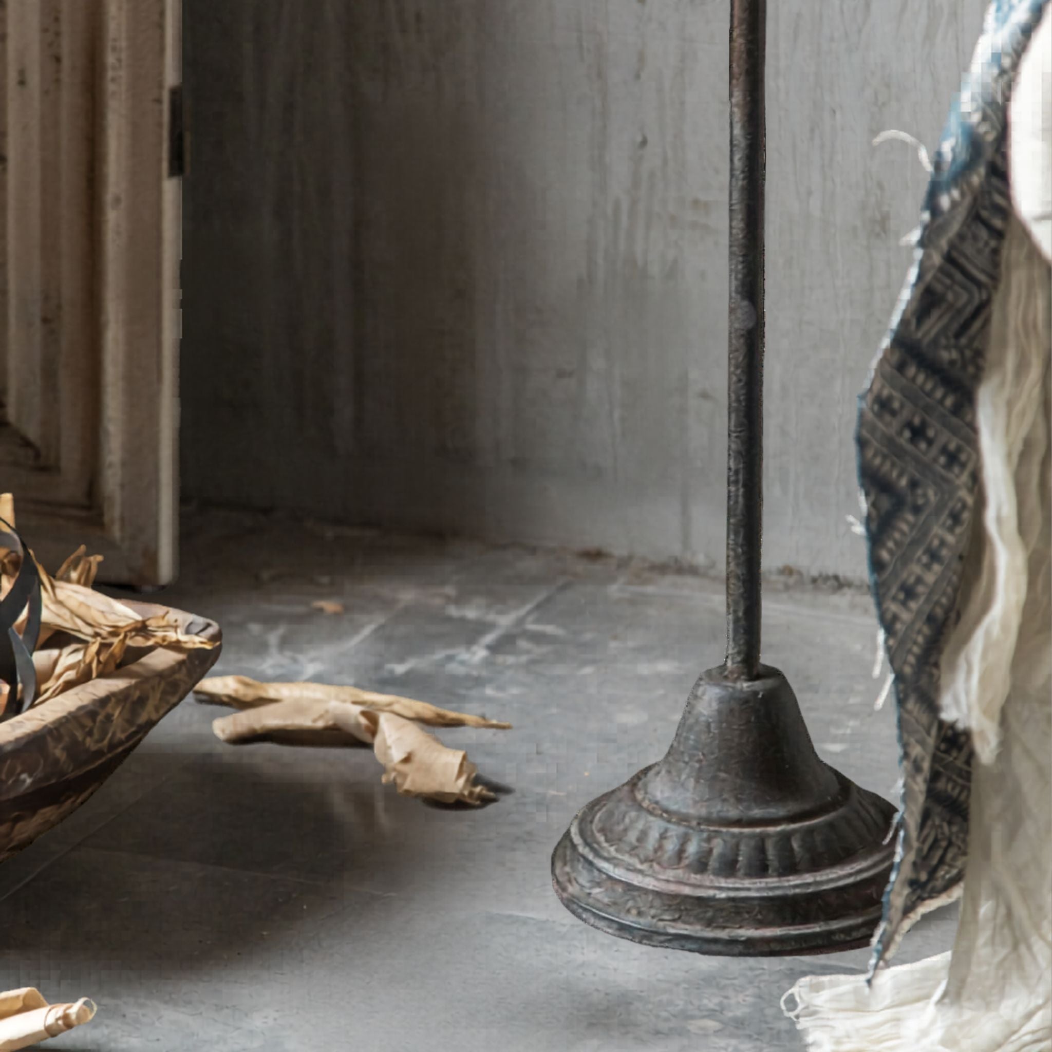 Close-up of the Florence floor candelabra base, a domed moulded disc in darker aged metal on the floor.
