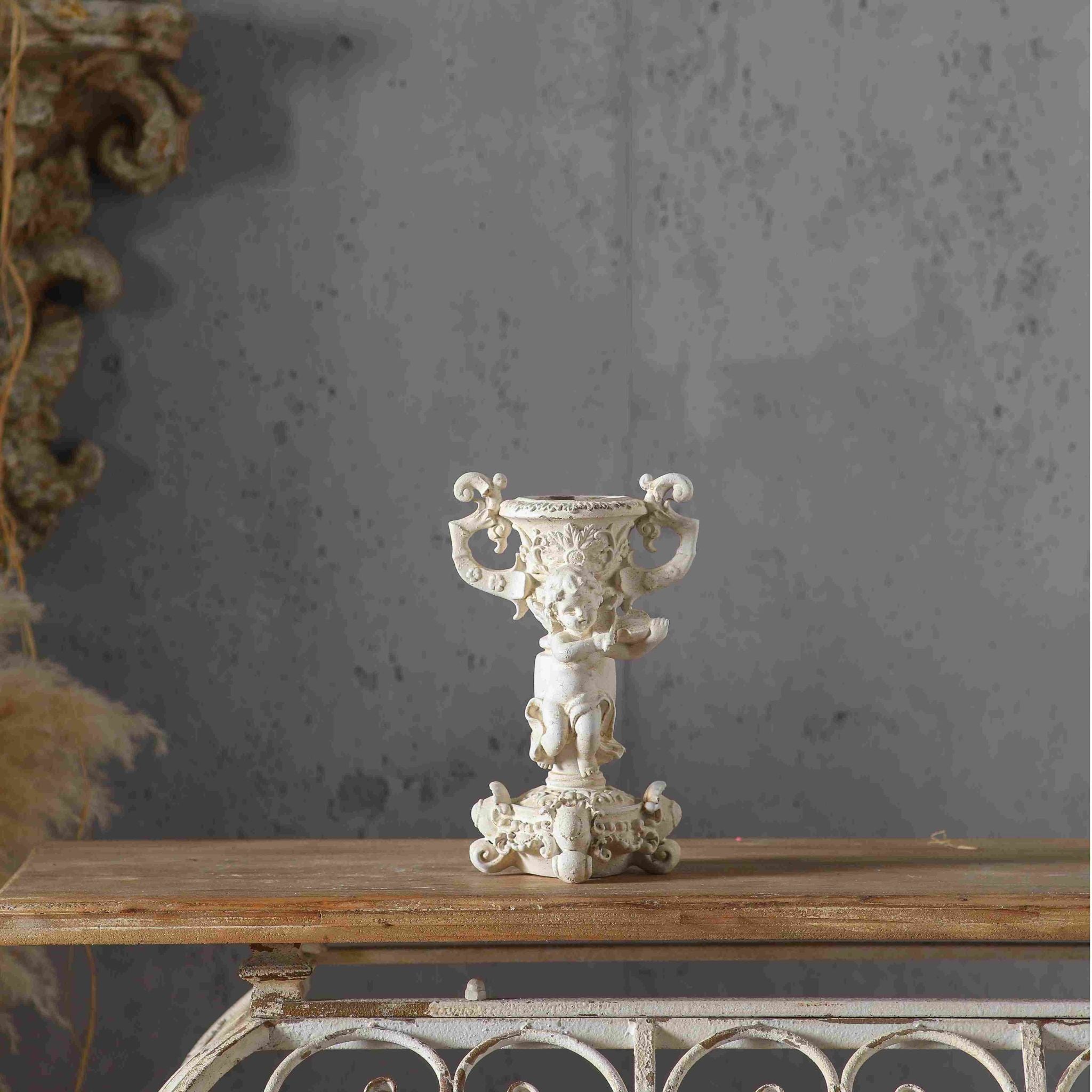 Jean Paul French Provincial cherub candle holder in antique cream, a putto holding a tambourine beneath an urn candle cup