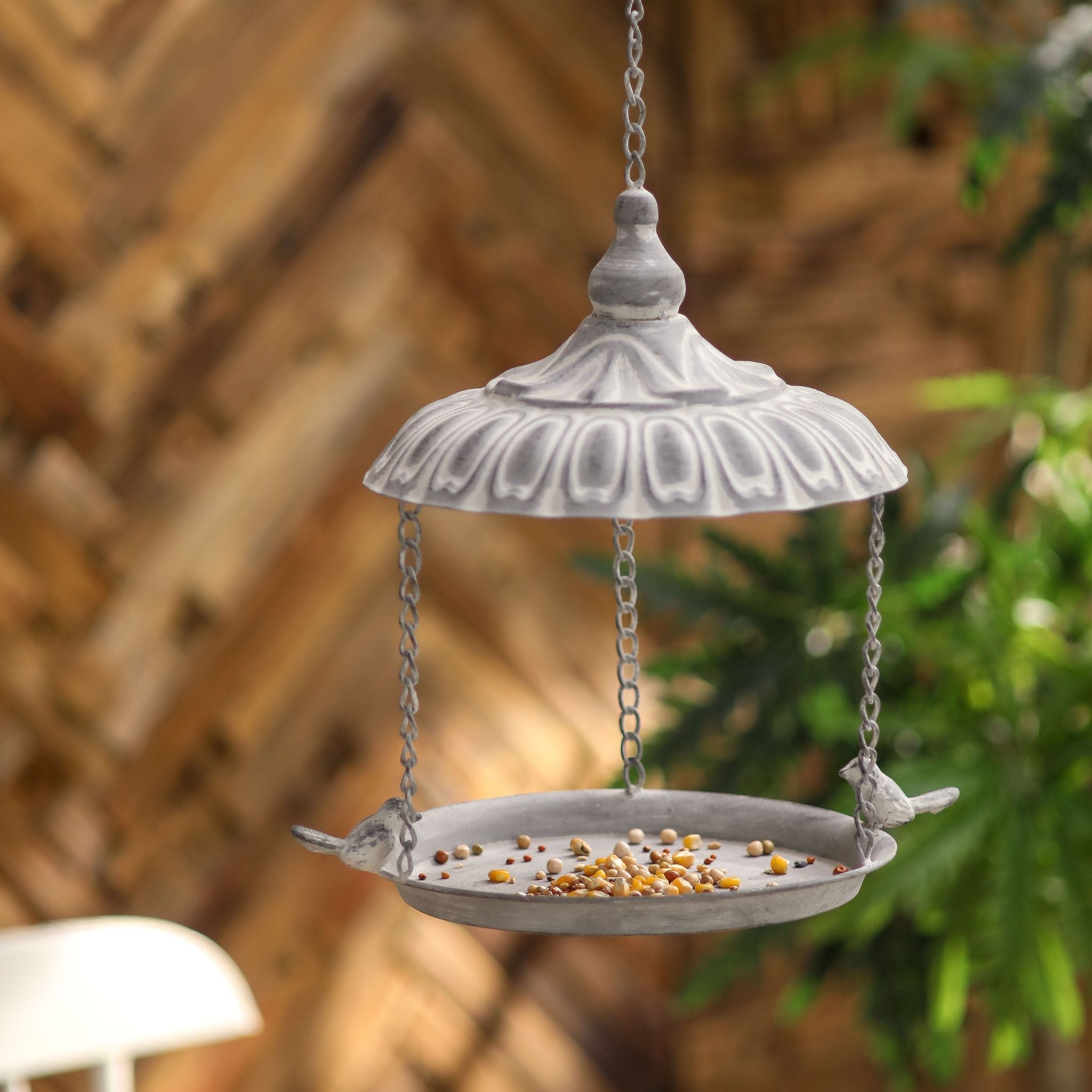 Dannielle whitewashed grey hanging bird feeder with a domed roof and seed tray, two little birds on the rim.