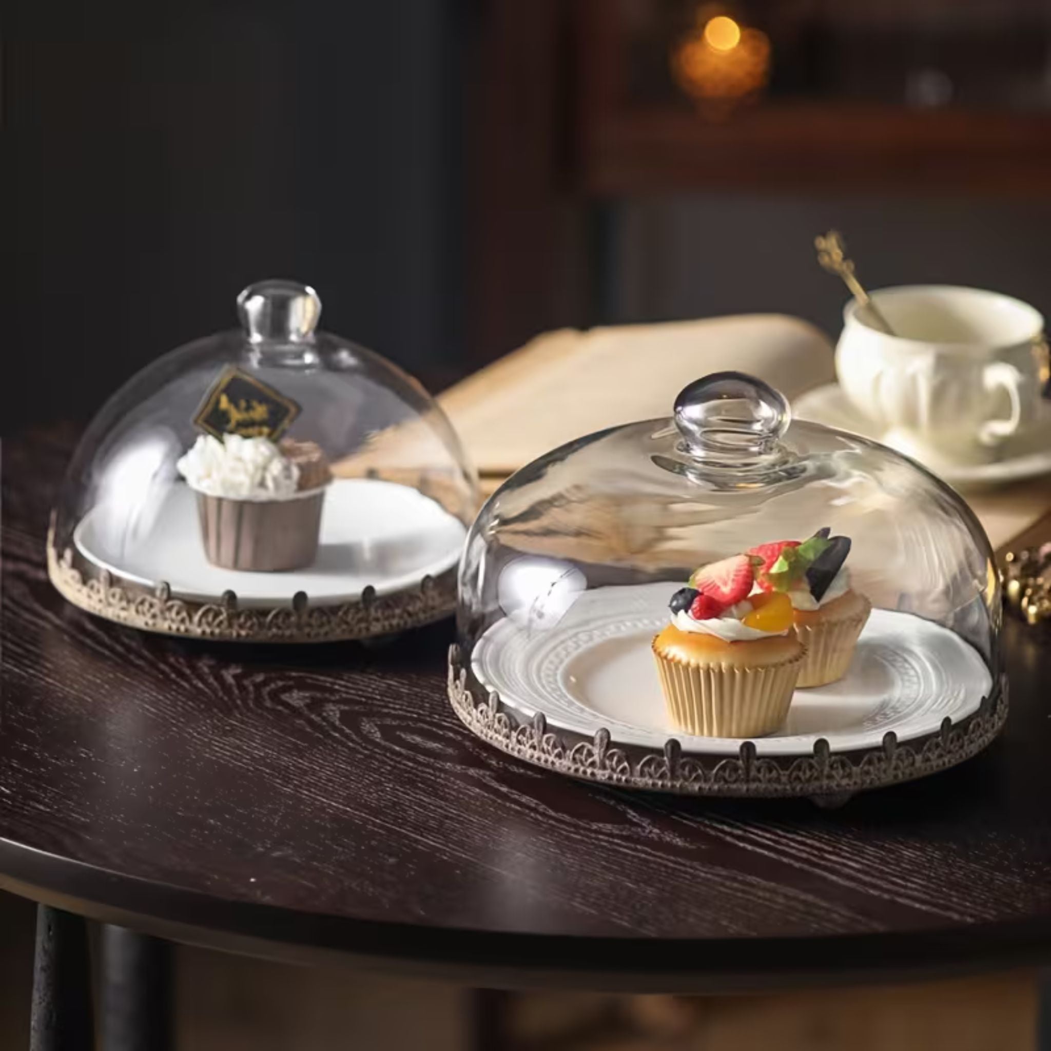 Honorine glass cake dome covering cupcakes on a table, styled for dessert display