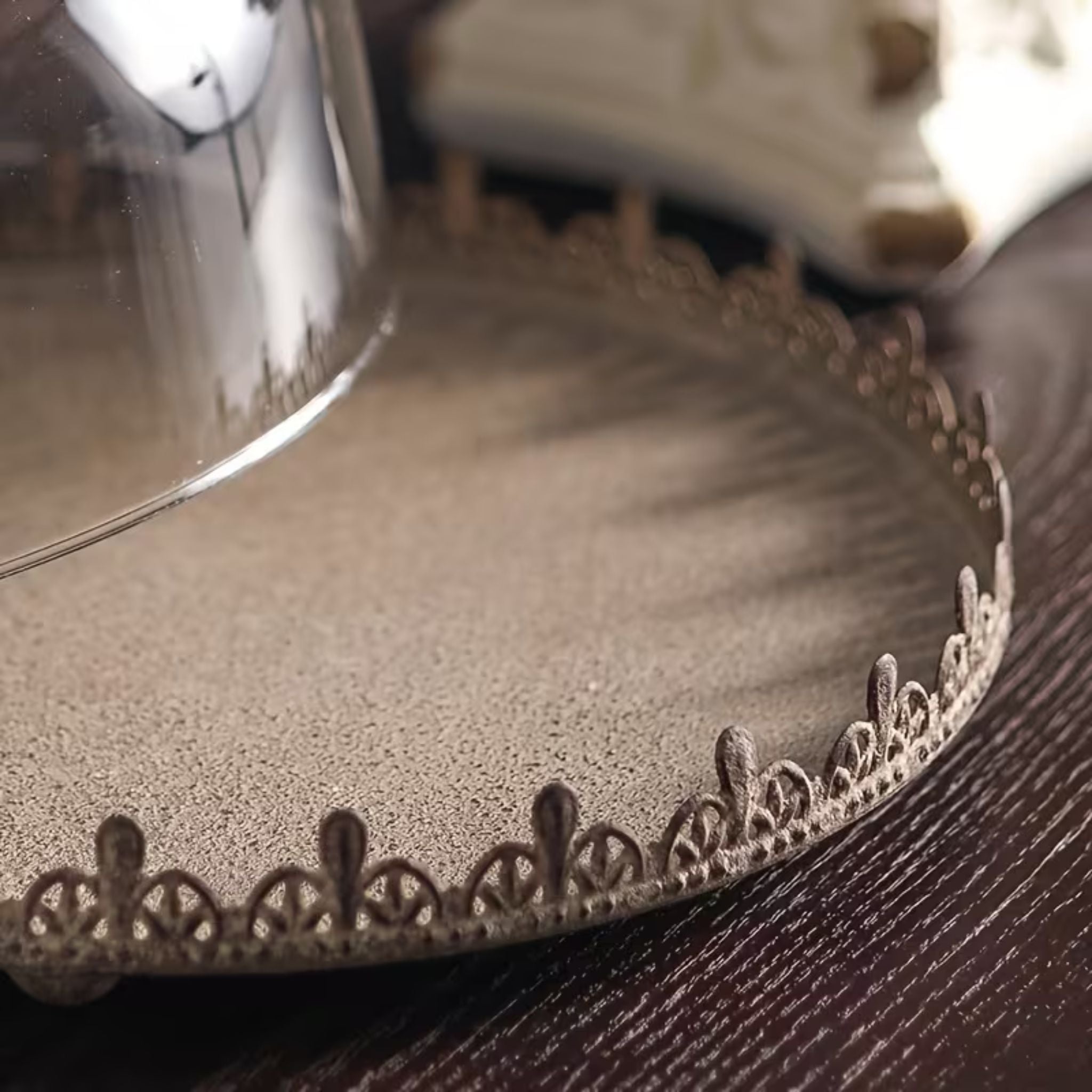 Close detail of the Honorine cake dome pierced crown edge and the clear glass dome resting on the metal tray