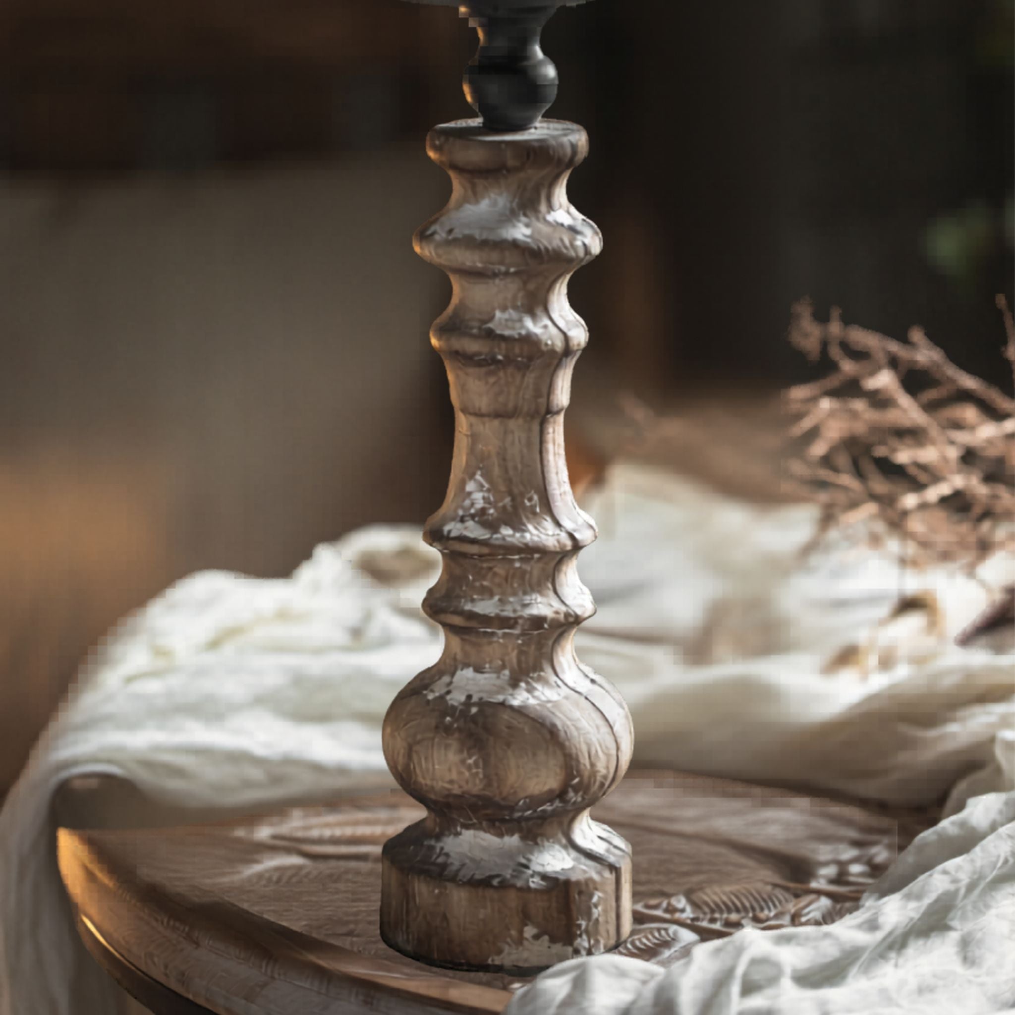 Close-up of the turned fir-timber column and stepped foot in distressed white, showing the white-rubbed grain.