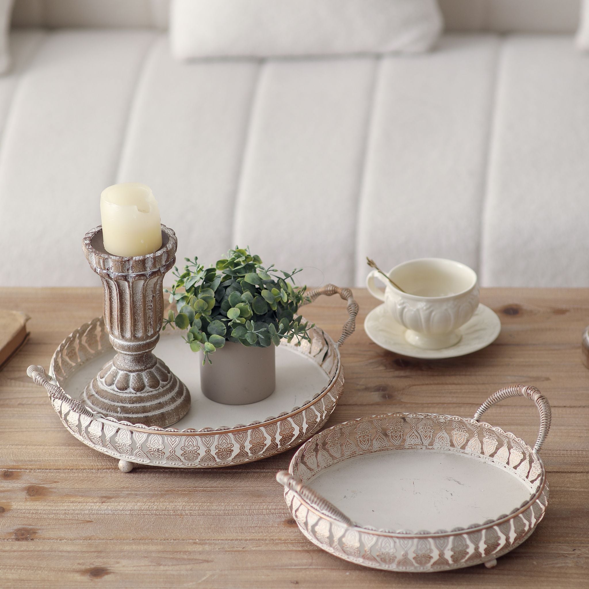 Jewel round trays styled on a table with a candle holder and plant, props not included