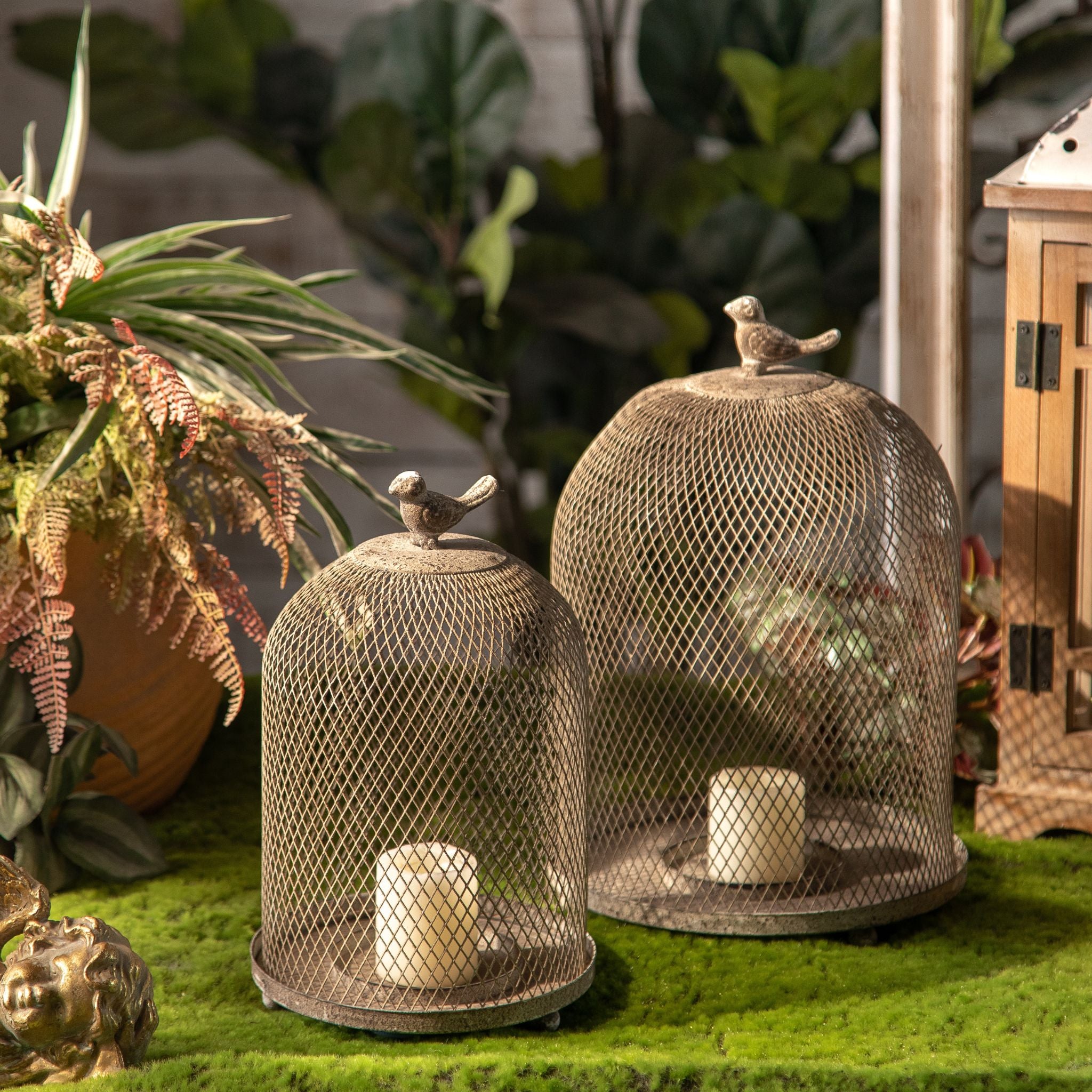 Joel pair of candle cloches in a garden setting, showing both sizes and the perched birds.