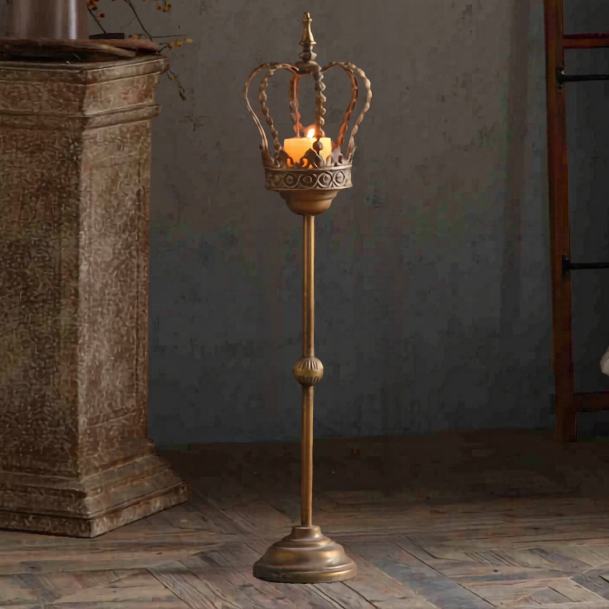 Joseph tall antique gold crown candle holder with a lit pillar candle