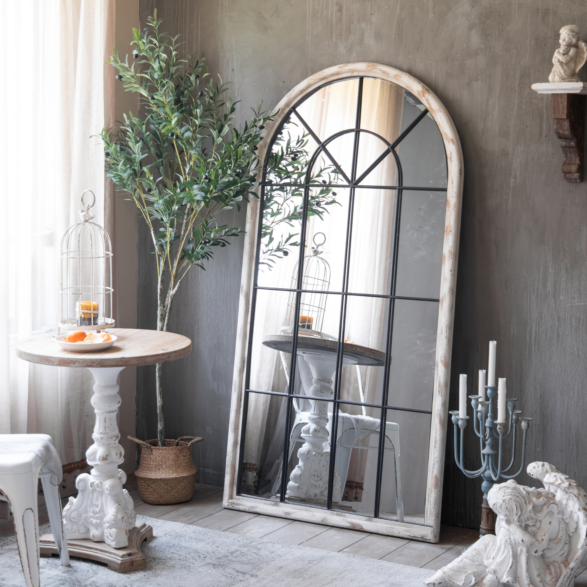 Laurent French Provincial Arch Floor Mirror with distressed timber frame and iron mullion grid, leaned in styled French country living room