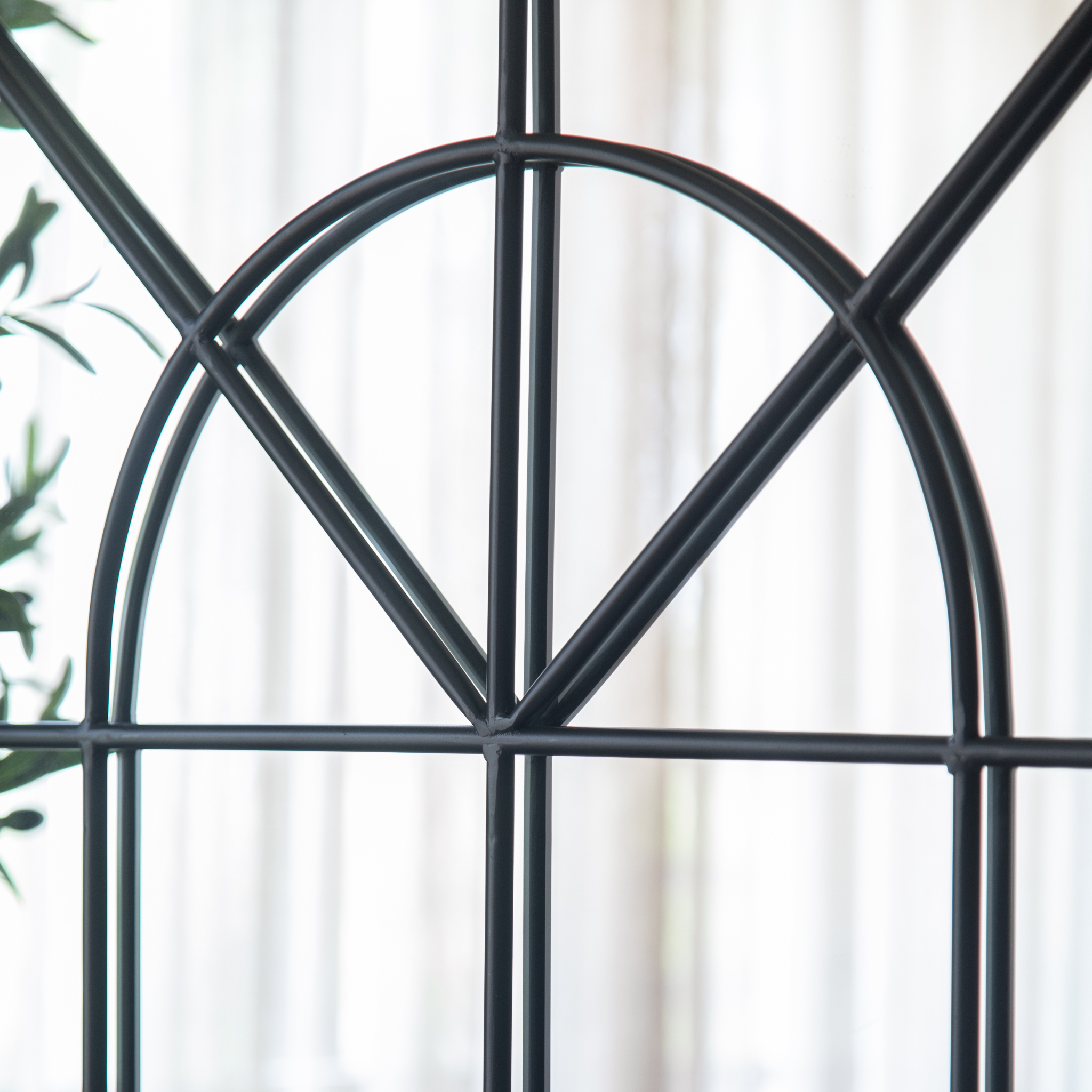 Black iron fan motif and mullion grid detail of the Laurent arch mirror