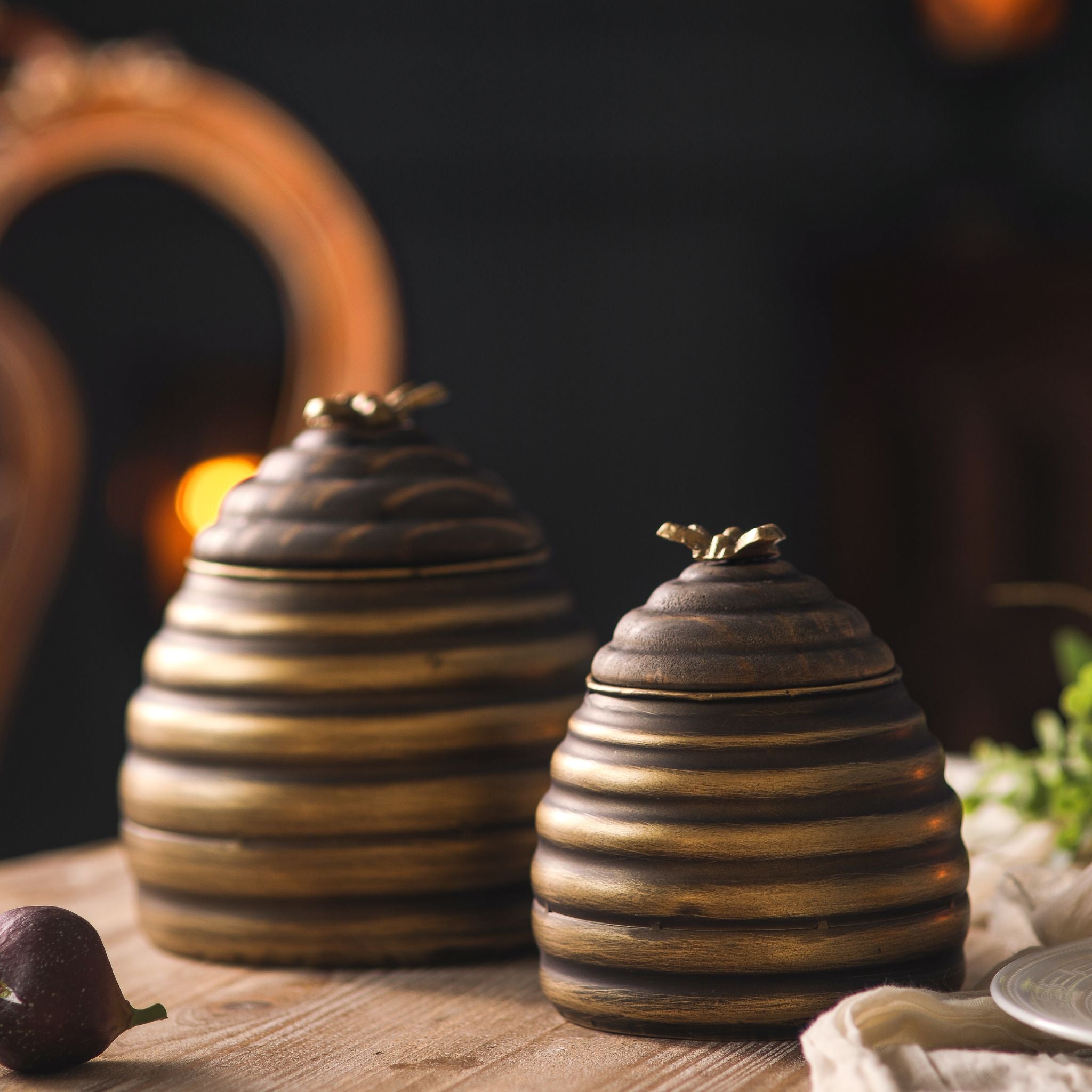 Leonie pair of antique gold beehive honey pots styled by candlelight with figs and a linen cloth.