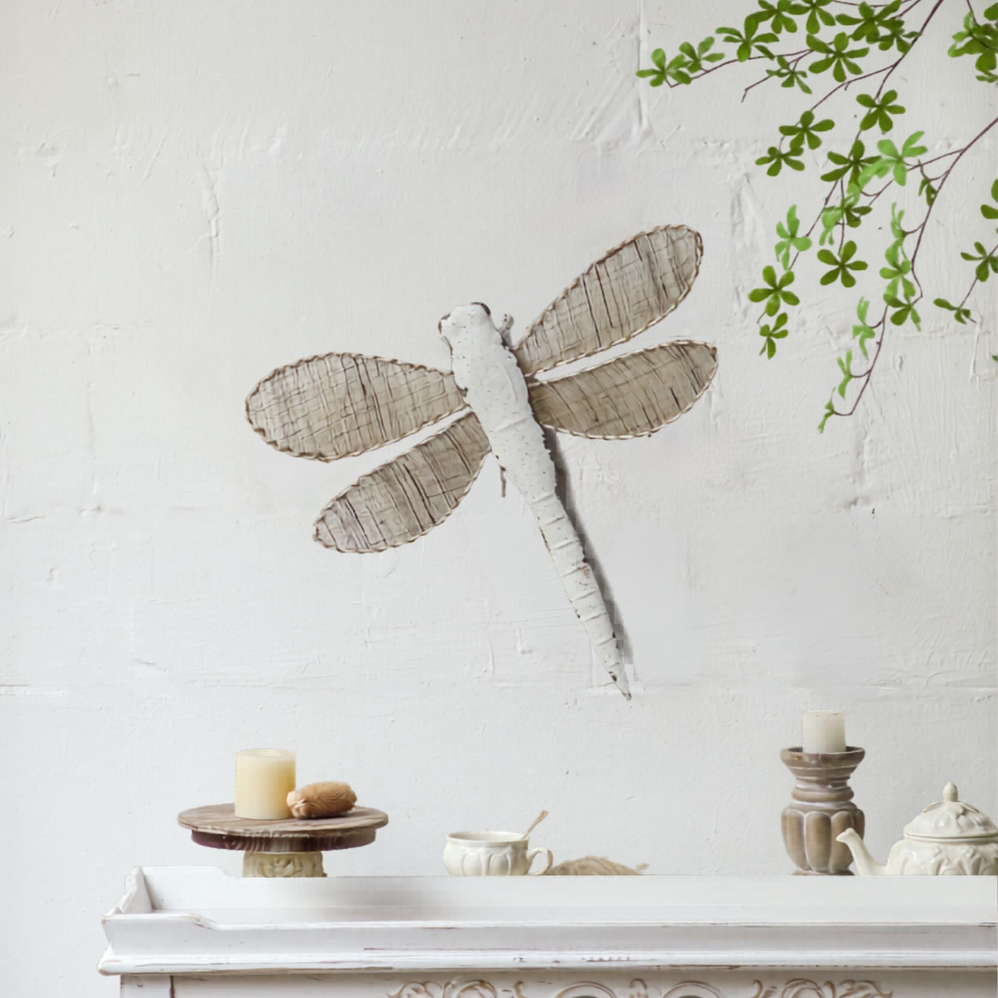 Distressed white dragonfly wall art with woven jute wings, hung above a white French Provincial console