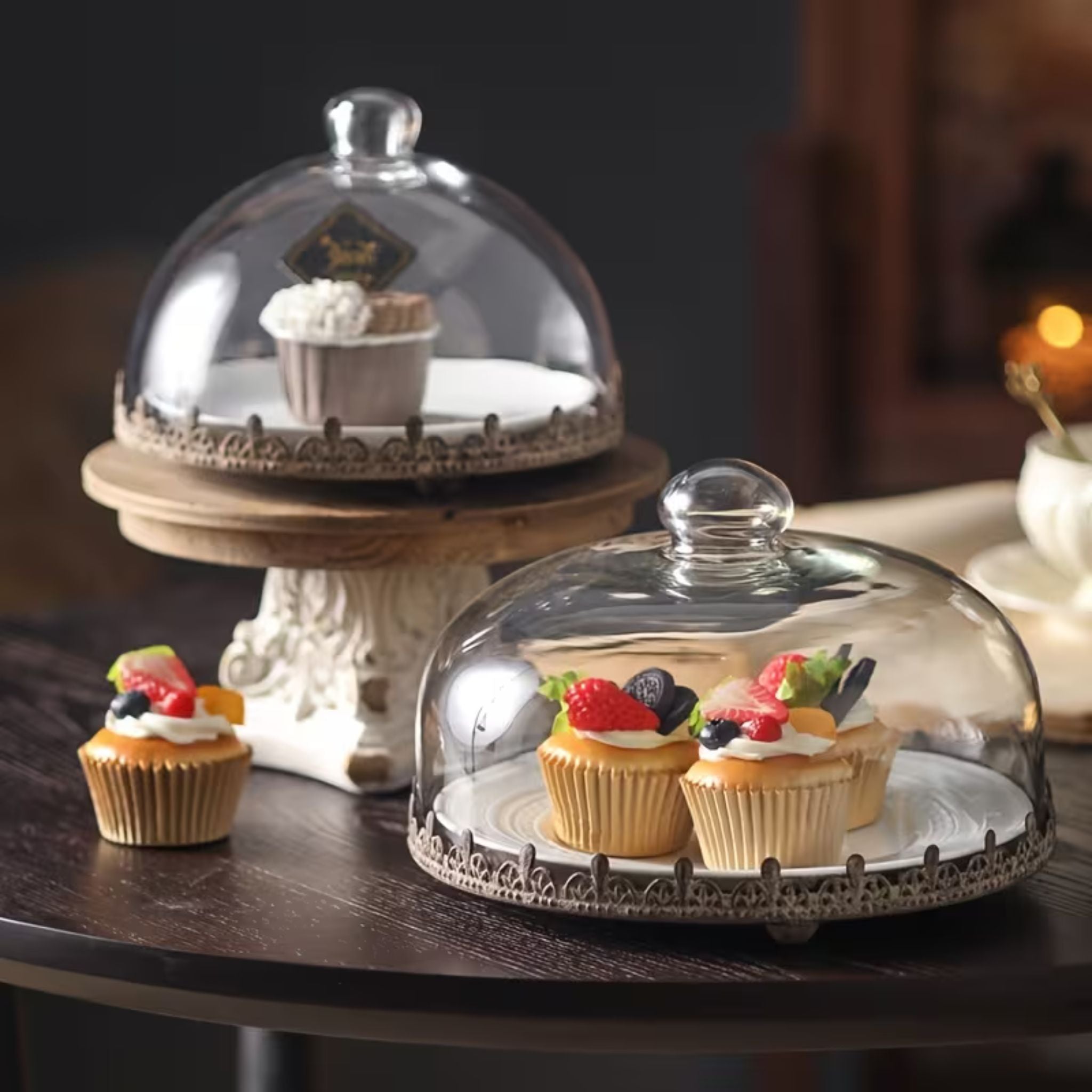Lilou glass cake dome covering cupcakes on a table, rustic rust-brown pierced edge tray
