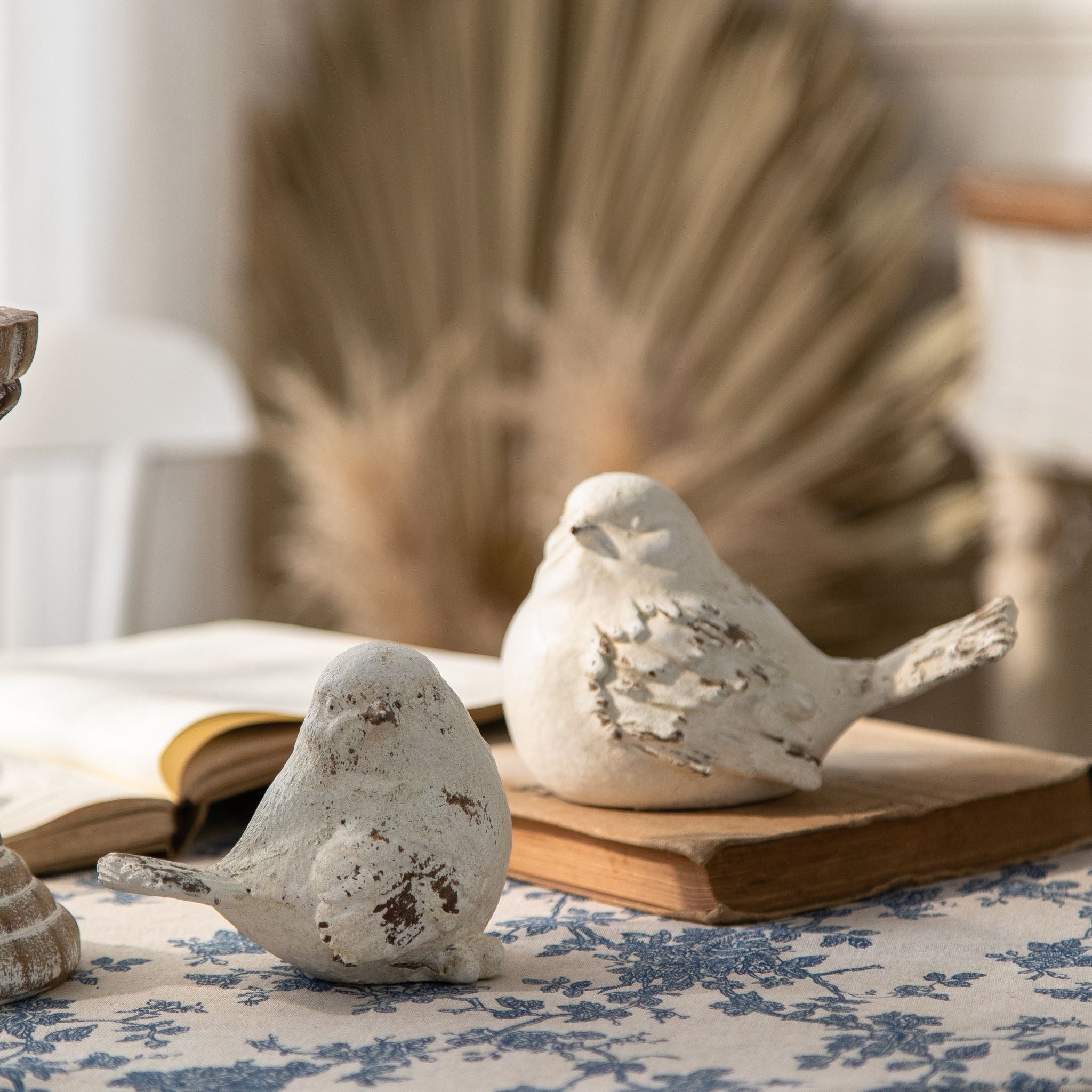 Close view of the Lucas bird figurines showing the carved wing feathers and the warm base tone through the whitewash