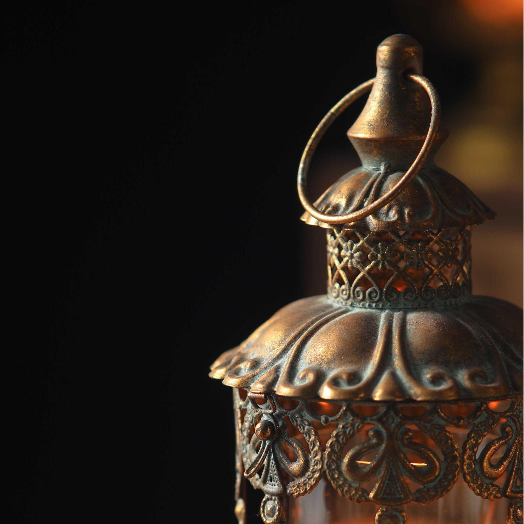 Close detail of the Mael lantern dome, scalloped antique gold with verdigris, pierced filigree skirt, ring handle and beaded chains.