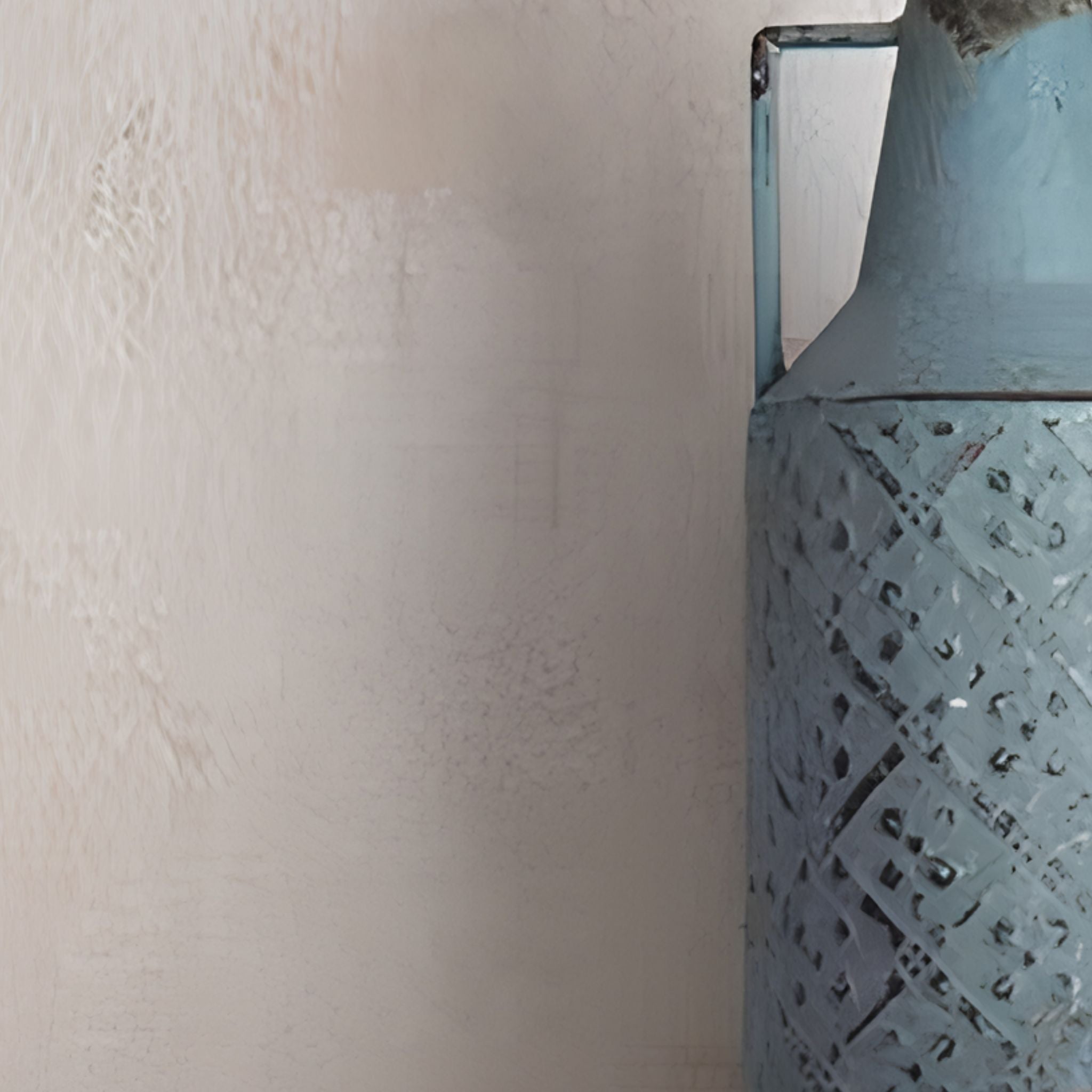 Close view of the Marianne blue bottle vase, embossed lattice texture and faded paint worn back to dark metal, single squared handle.