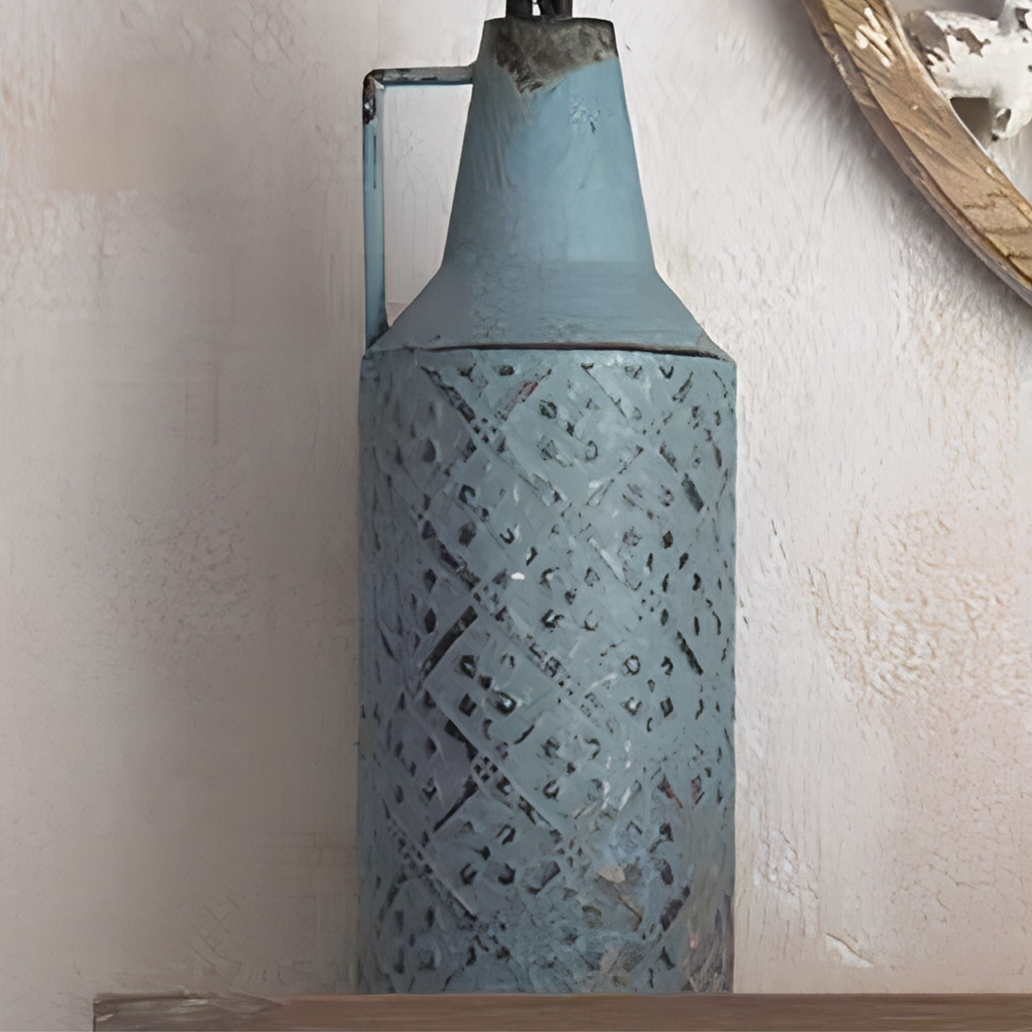 Marianne distressed blue bottle vase with embossed lattice and a single handle, empty, on a timber shelf. 