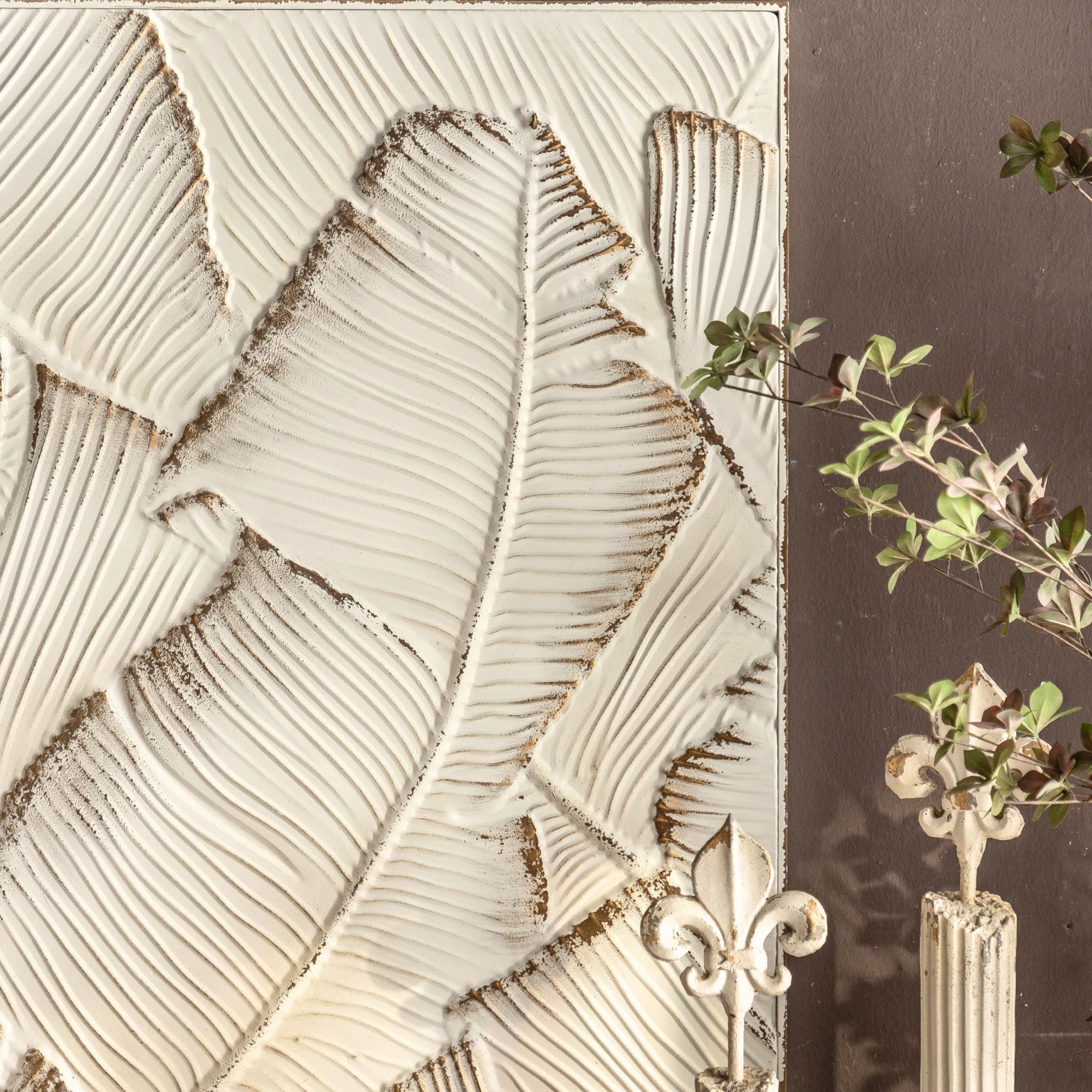 Close-up of the embossed banana leaf relief on the Marshall panel, distressed white with gold in the grooves.
