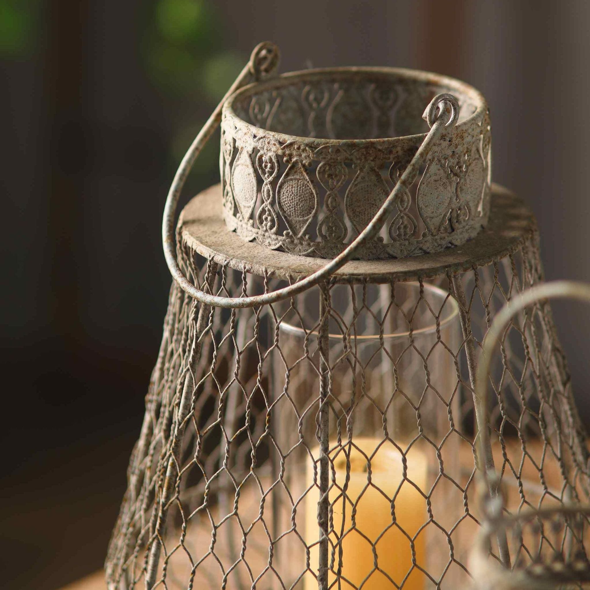 Close detail of the Martine lantern's ornate embossed metal collar and looped handle in weathered grey.