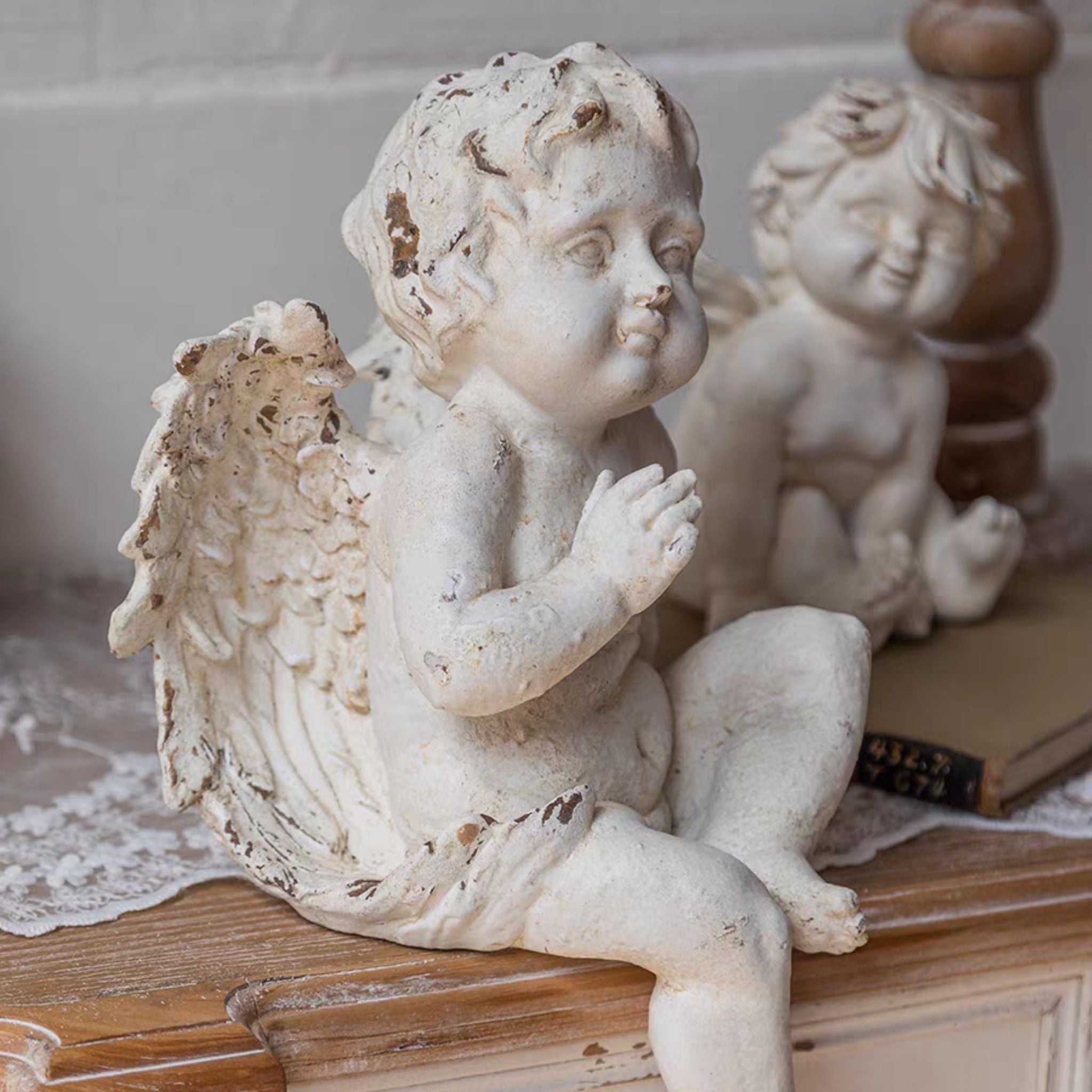 Side profile of Maxime cherub figurine showing the full wing detail and the contemplative head turn