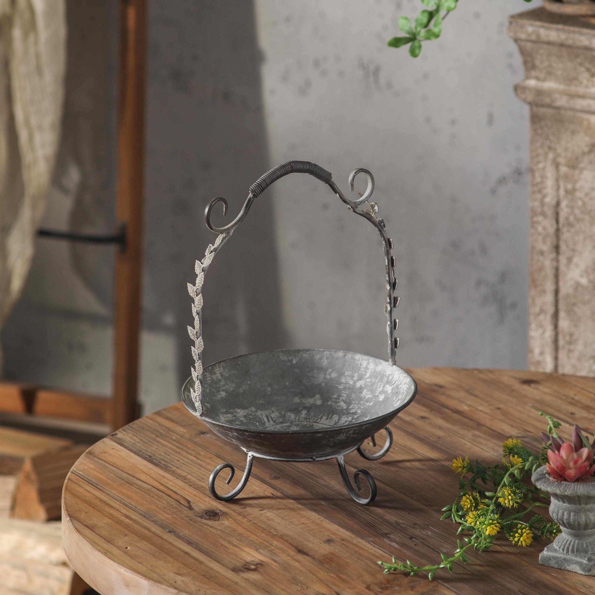 Single Meline handled basket showing the full form, bowl, scrolled feet, and arched handle.