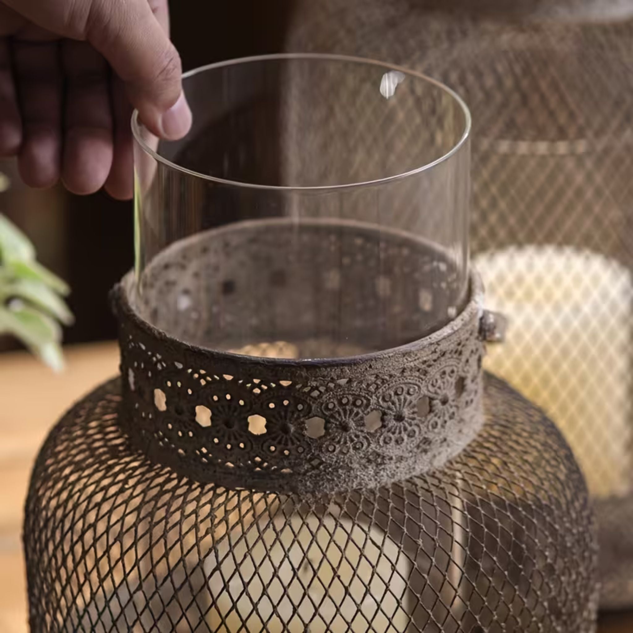 Hand lifting the removable glass sleeve out of the Maurice mesh lantern