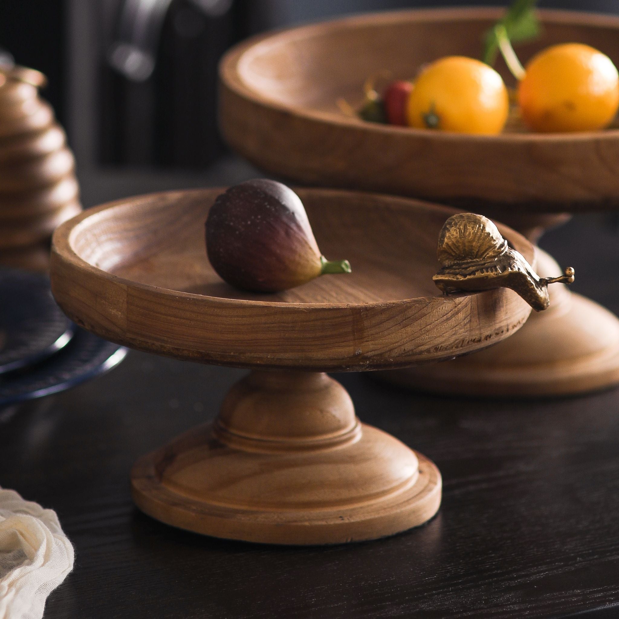 Mia footed wooden tray styled with a fig, showing its smaller proportions.