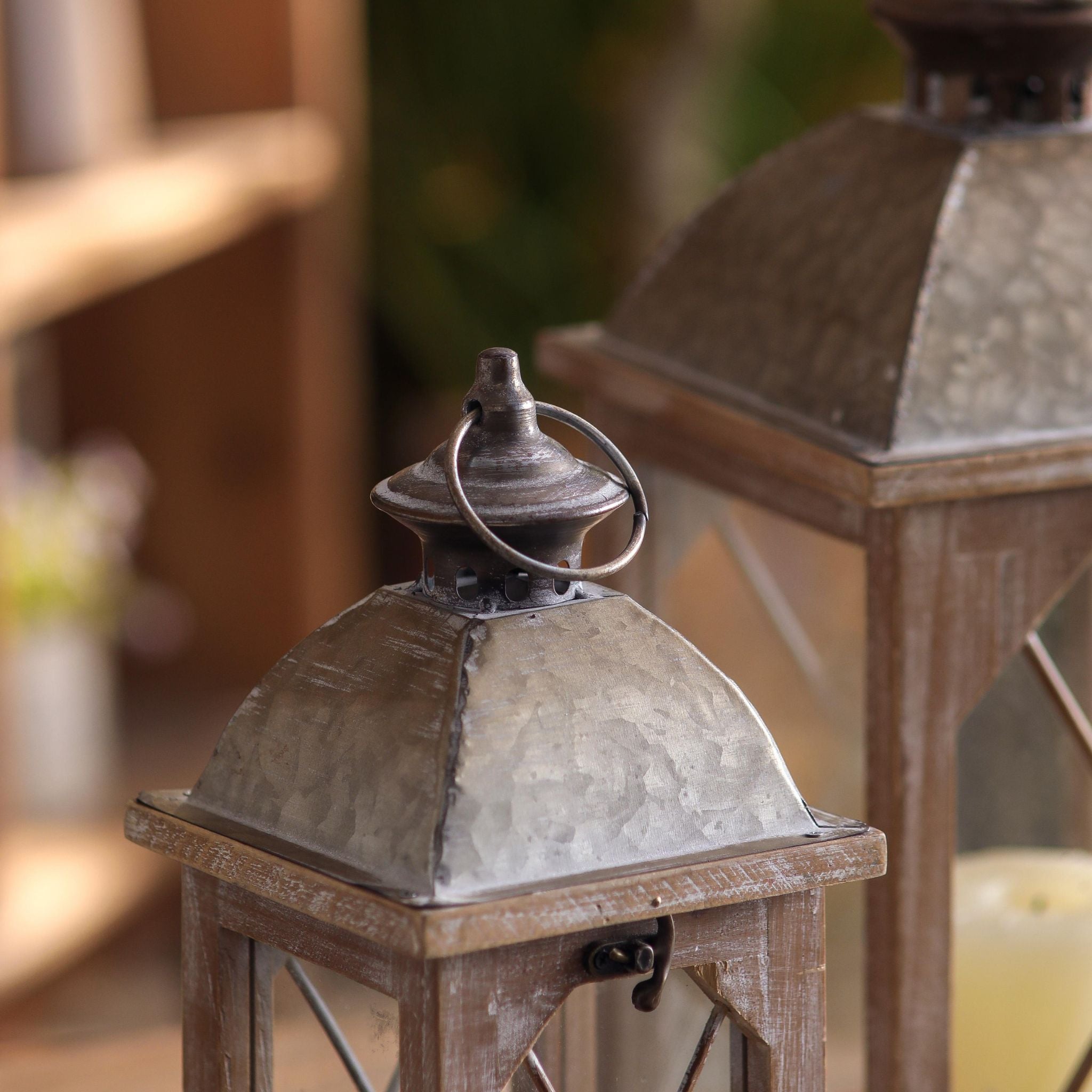 Close-up of hammered galvanised metal dome and ring handle on a small wood lantern