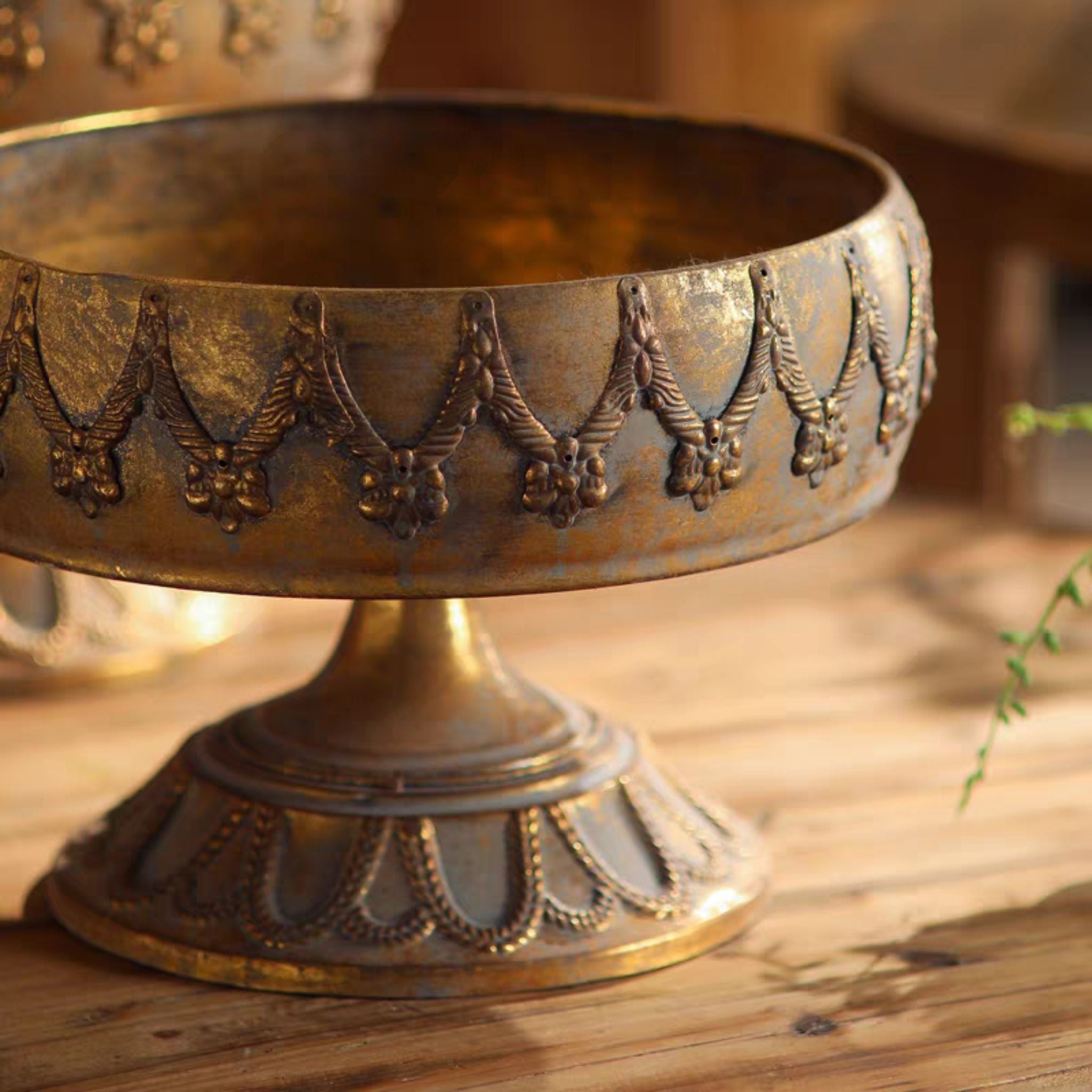 Close view of the swag relief band and pedestal foot on the Nicolette antique gold compote bowl
