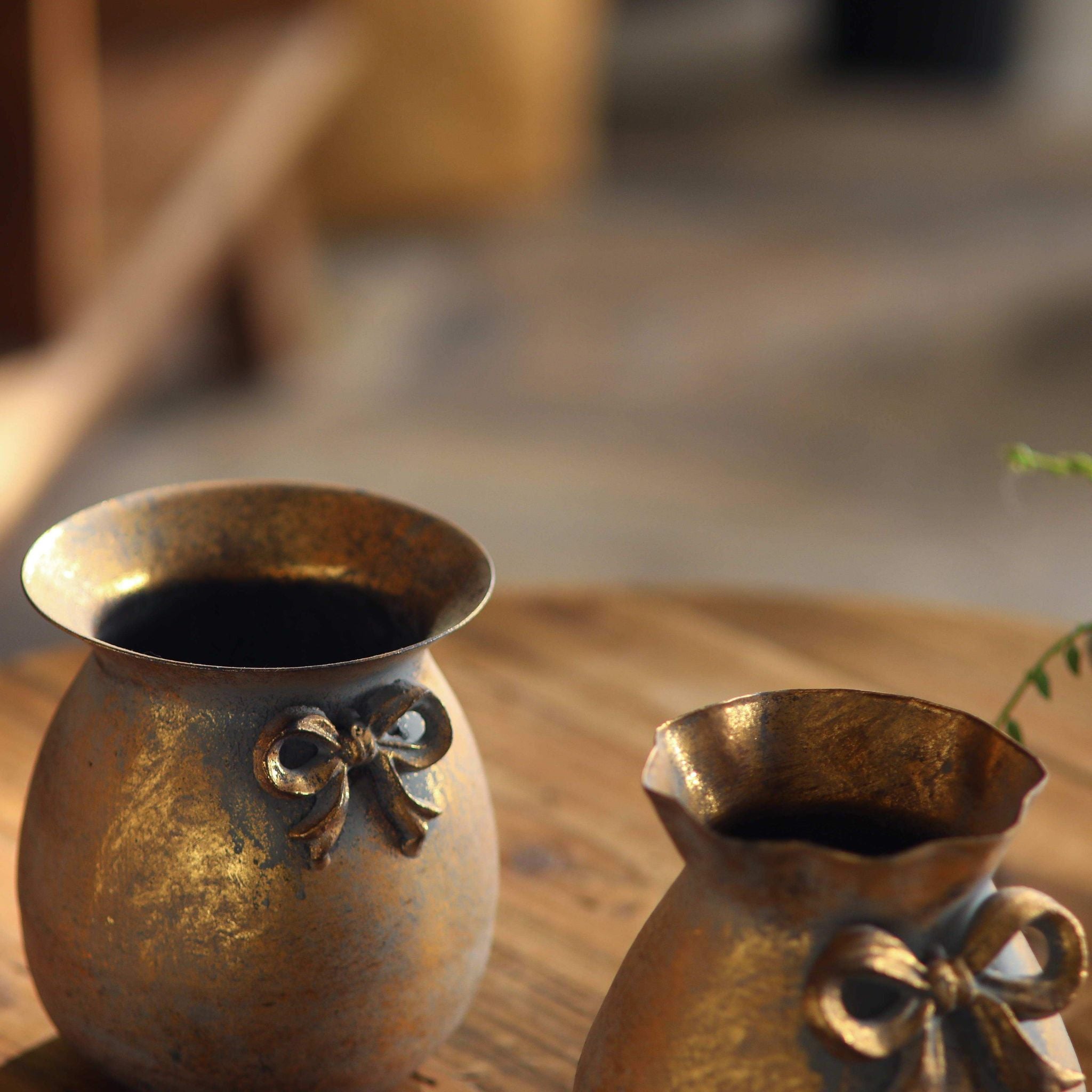 Noel bow vases, close view of both pots showing the flared and ruffled rims and gold interiors.
