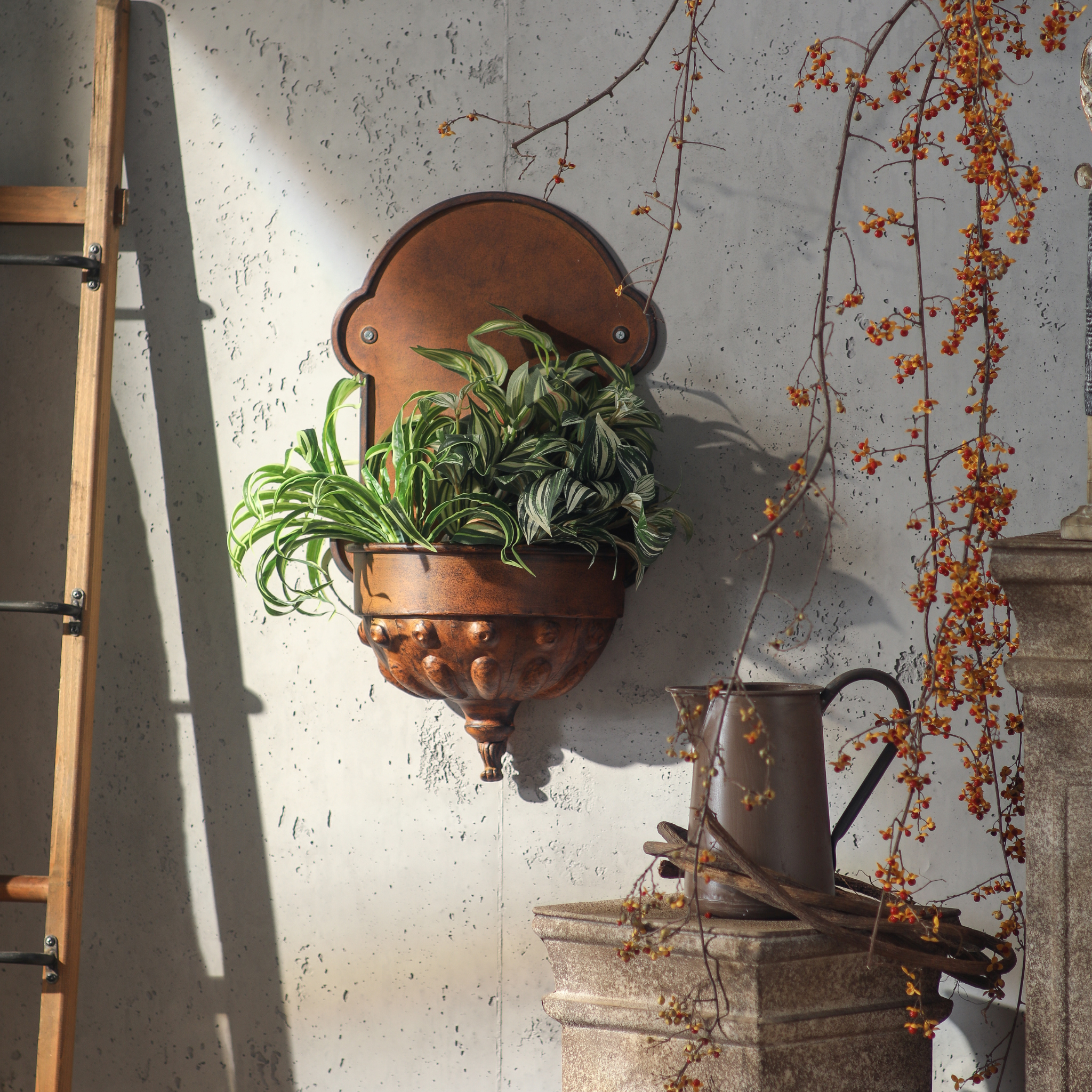Olivier French Provincial wall planter in aged copper, styled with trailing spider plants and tradescantia in a French country setting