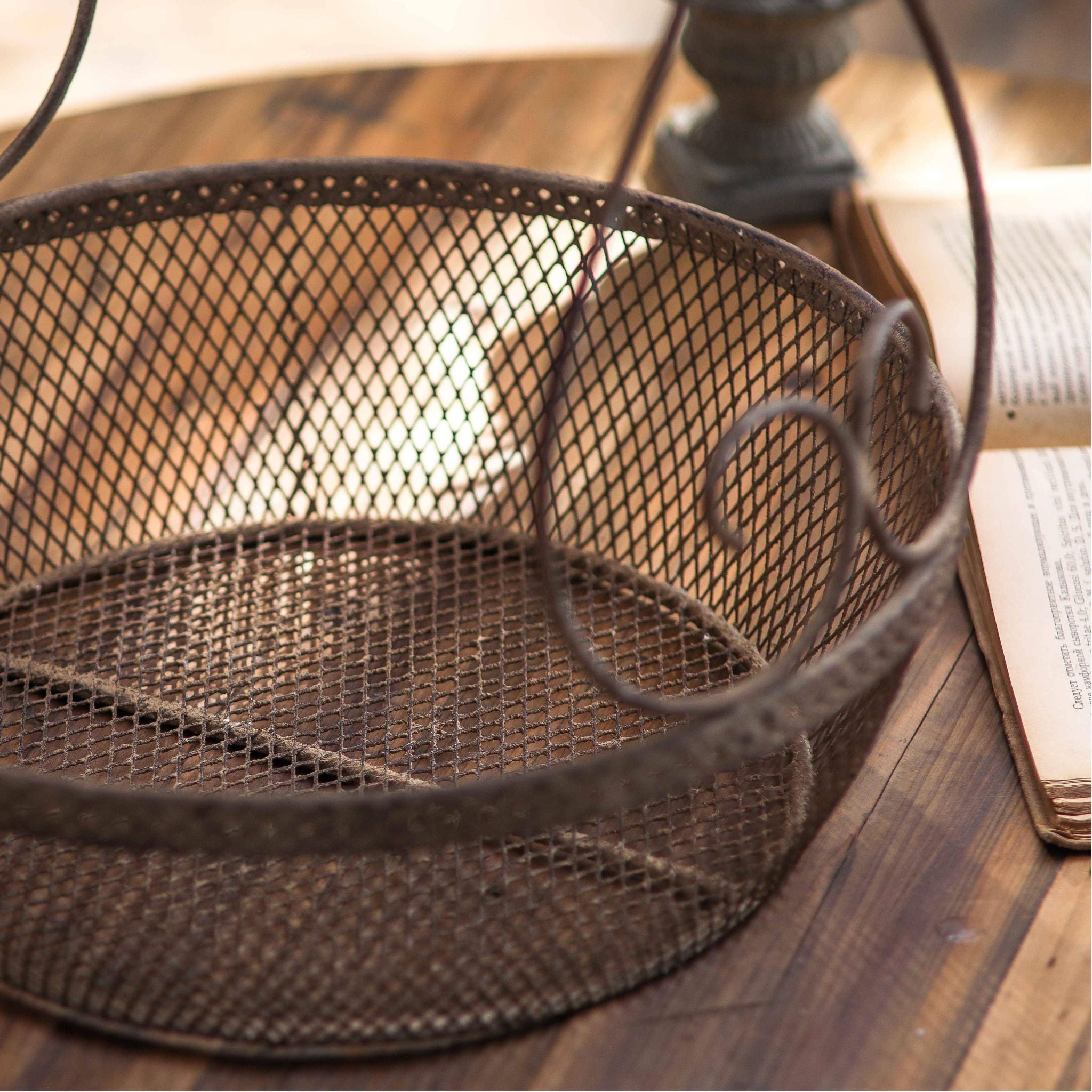 Oscar two tier basket carrier shown empty from above, showing both mesh baskets and the scrolled handle.