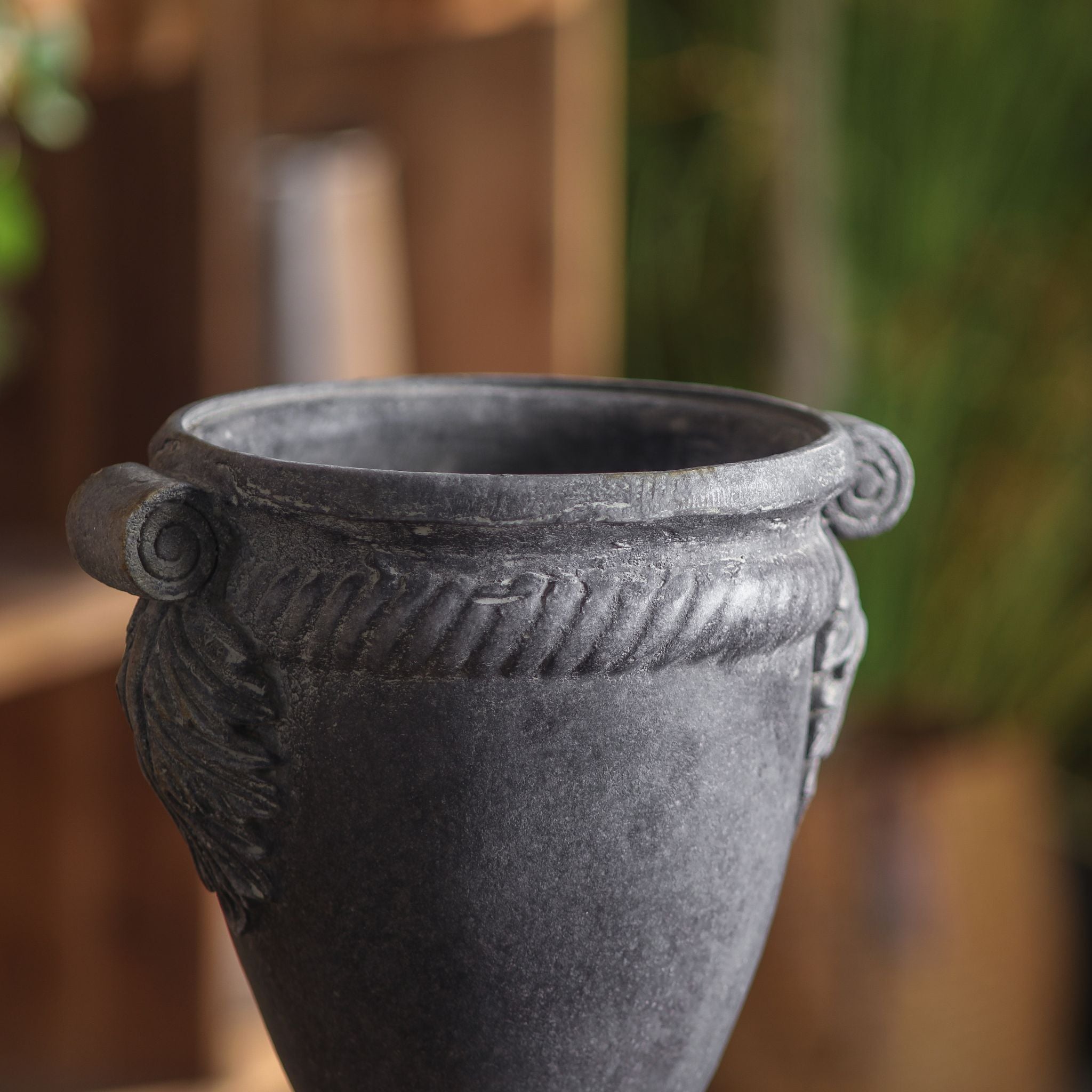 Close-up of the Patrick urn rim, Ionic scroll handle, acanthus and cabled collar in a weathered lead-grey.