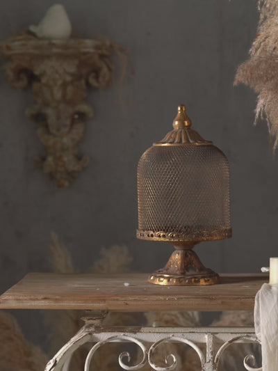 Antique gold mesh dome candle holders on pedestal stands, shown lit in a styled French provincial setting