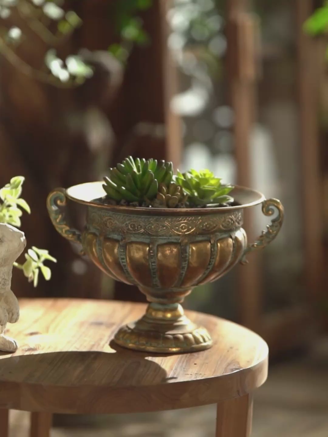 Dominique antique brass footed urn planter, detail pan across the embossed bowl and handles, styled with succulents.