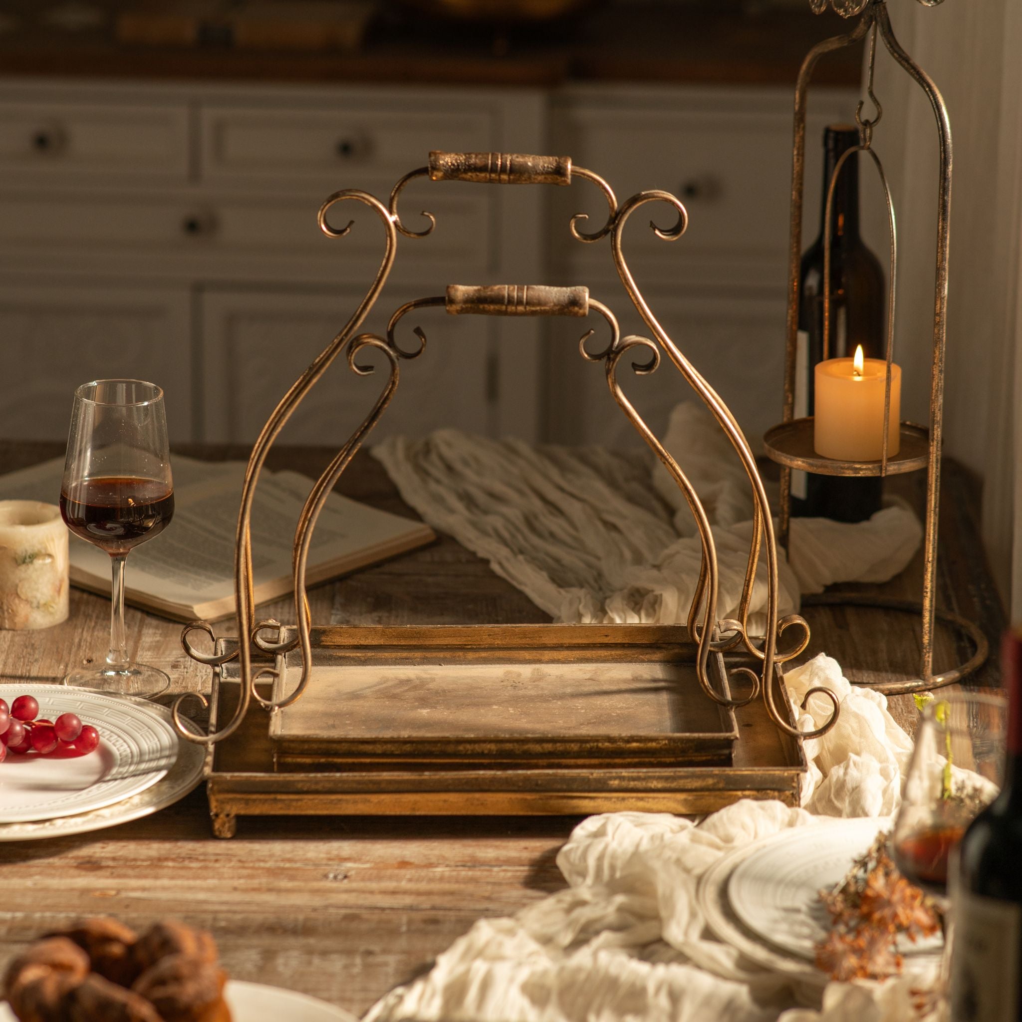 Bothe nested Risette handled tray in antique gold metal, front view with scrolled carry handle.