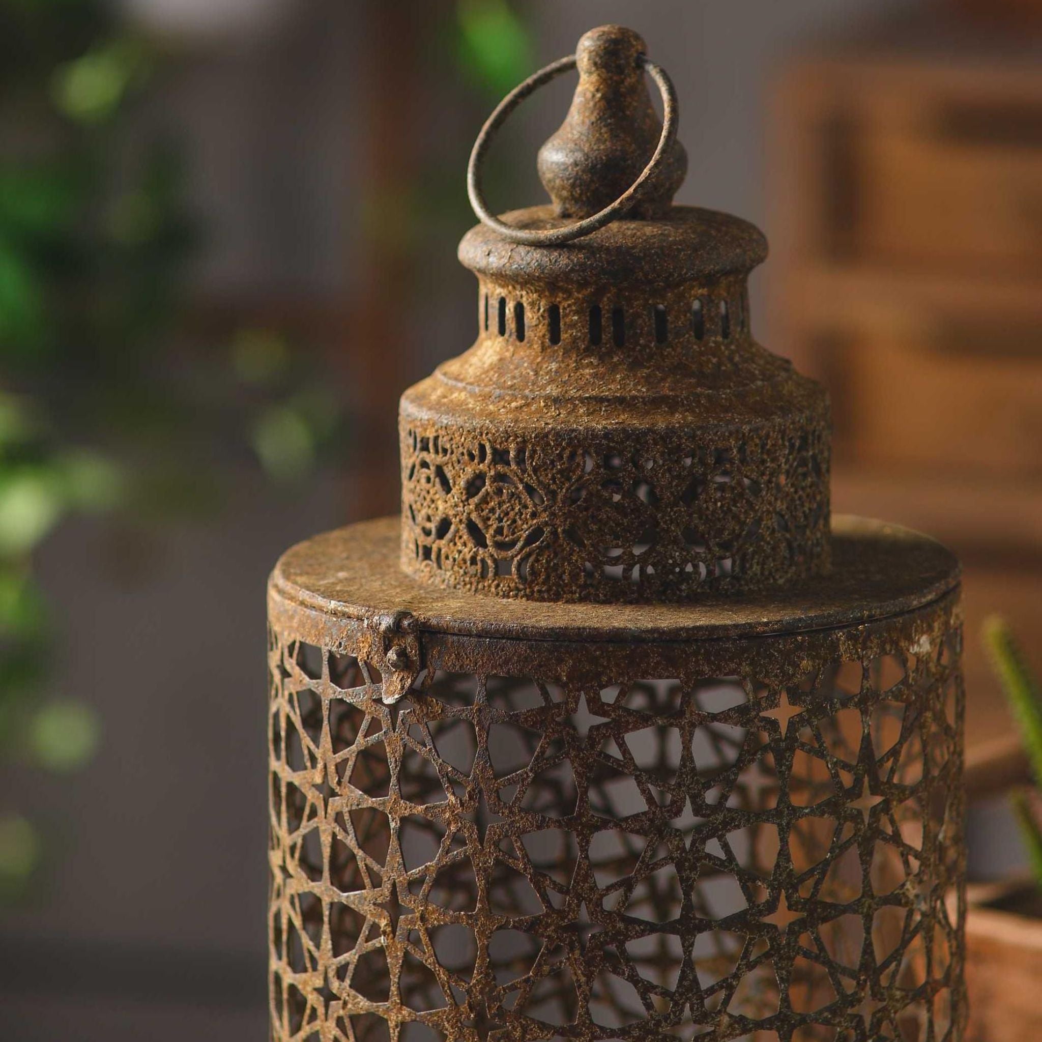 Close detail of the Rueben lantern domed cap, pierced aged metal with a weathered rust finish, ring handle and finial.
