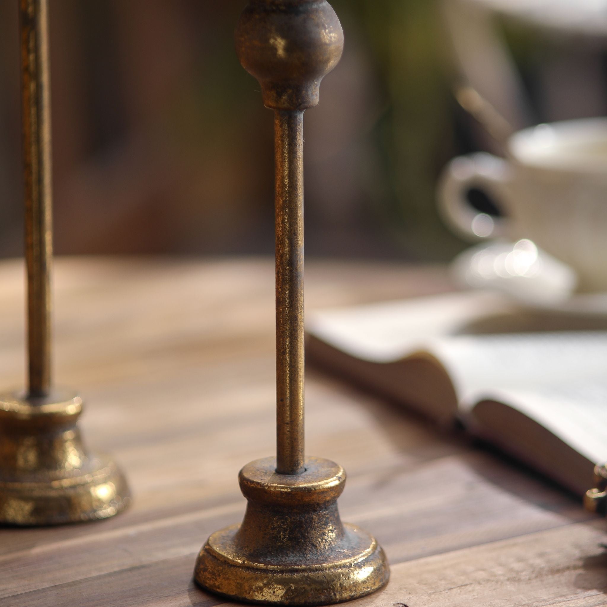 Detail of the Karine taper candlestick slim stem and turned foot in aged gold metal