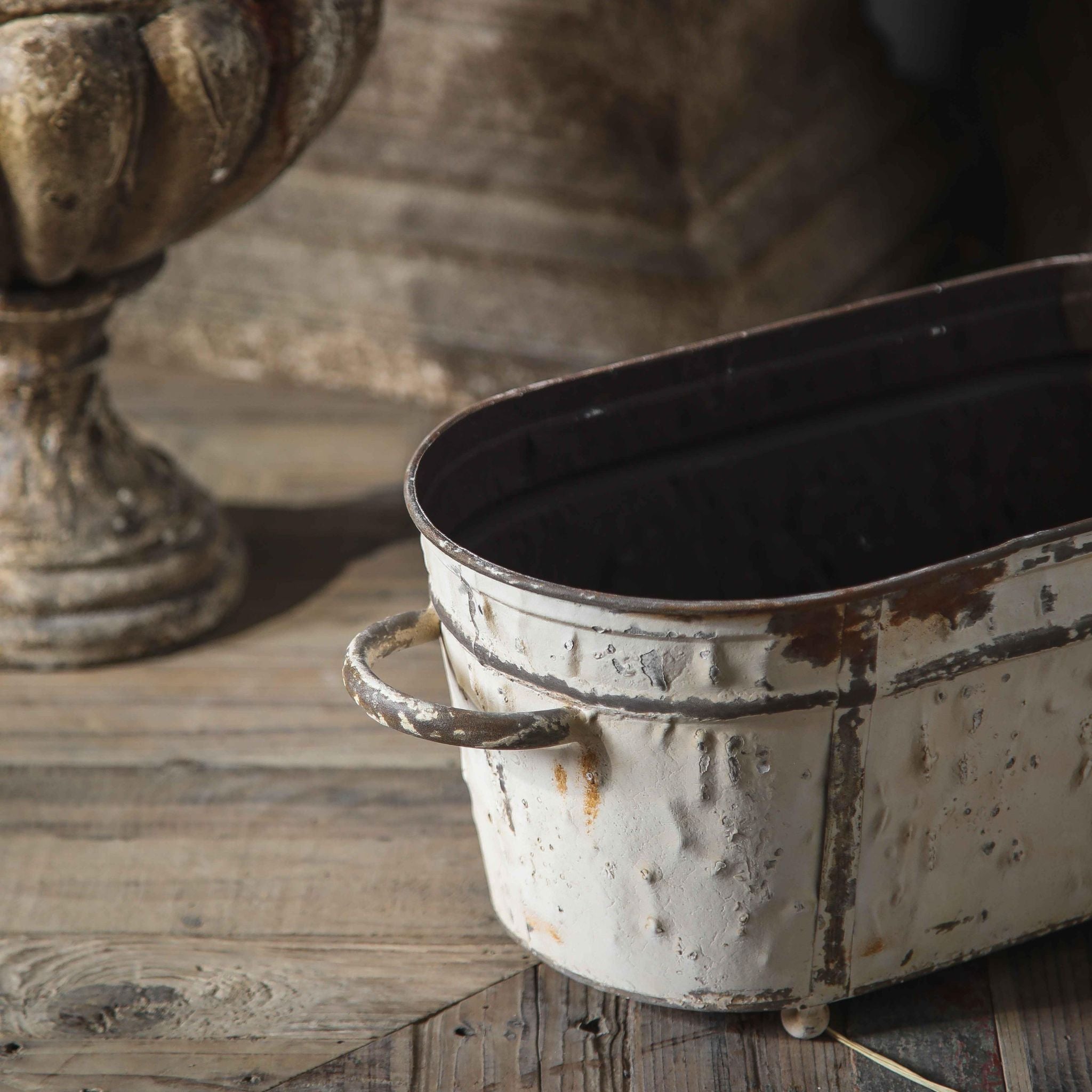 Close-up of the handle, rim and distressed white finish on a Lucie trough planter