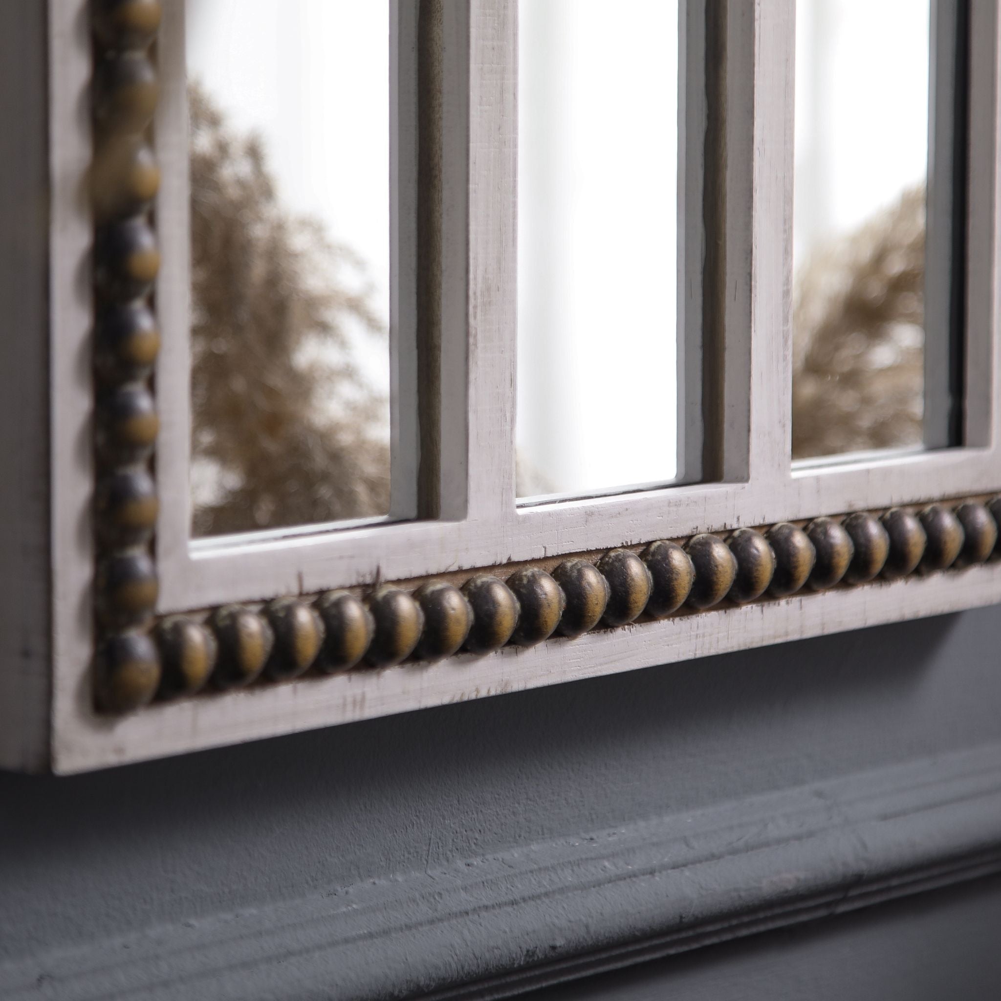 Close-up of Vincent's lower mullion bars and beaded trim showing the worn whitewash and antique gold patina on the beading.