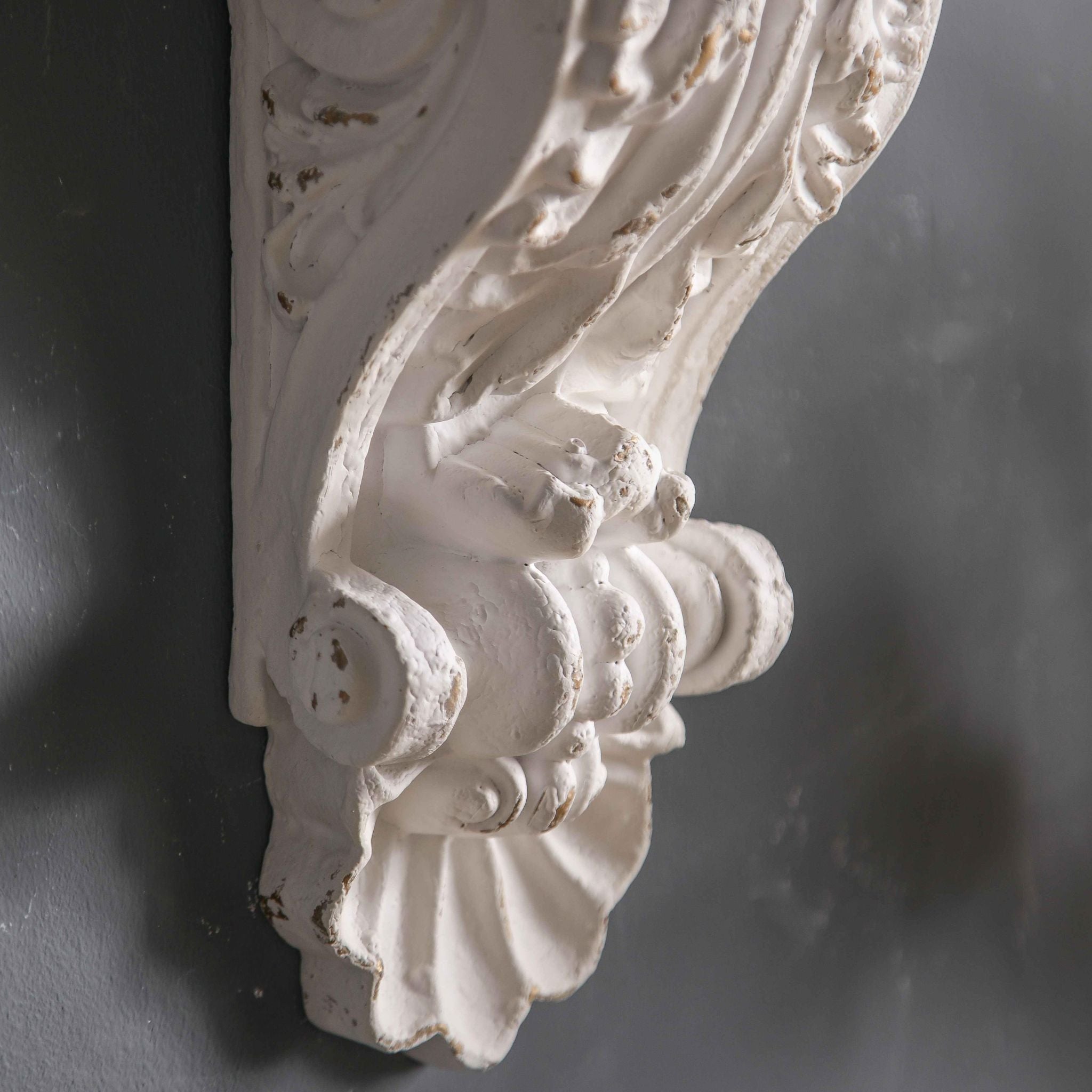 Viviane corbel wall shelf close-up of the acanthus scroll and shell with a chippy white finish
