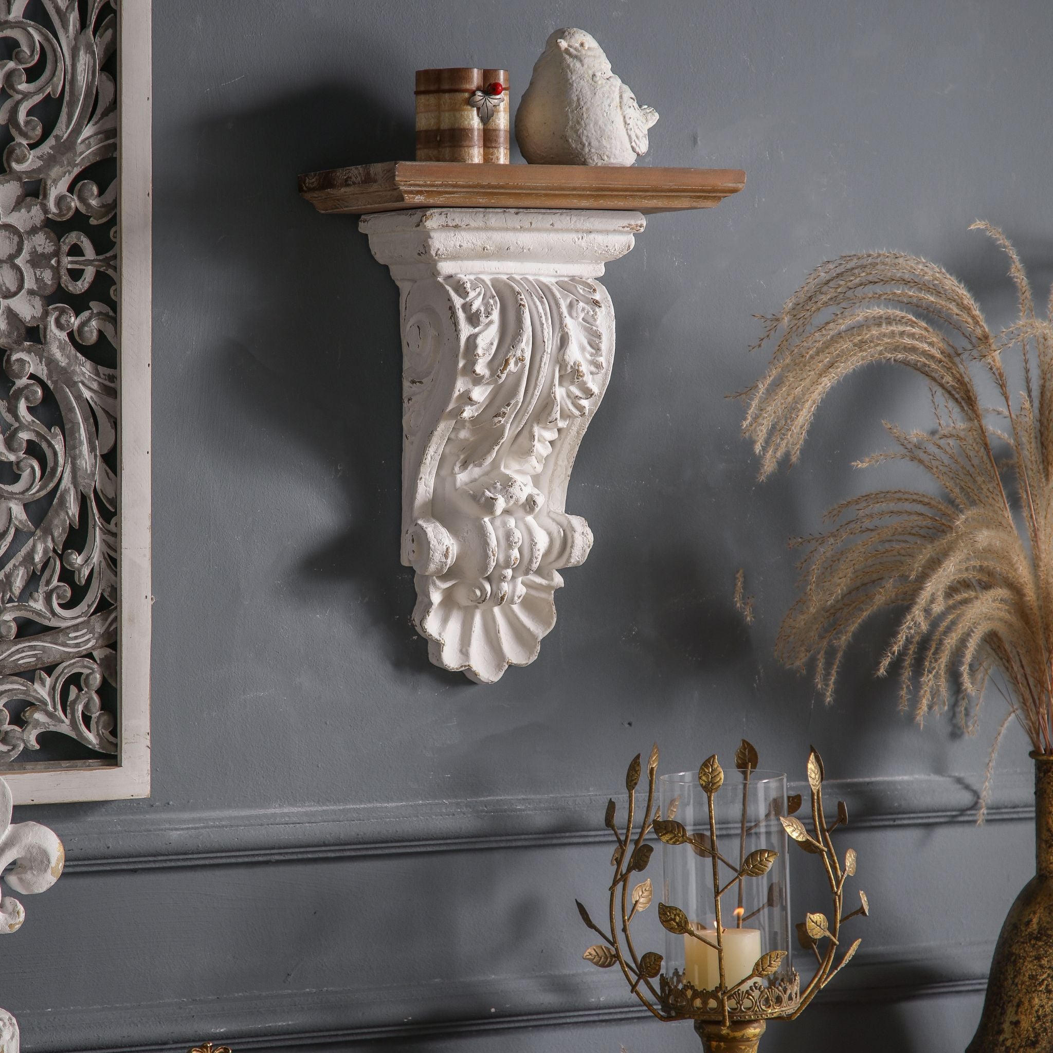 Viviane corbel wall shelf styled with a small bird and books beside a carved panel