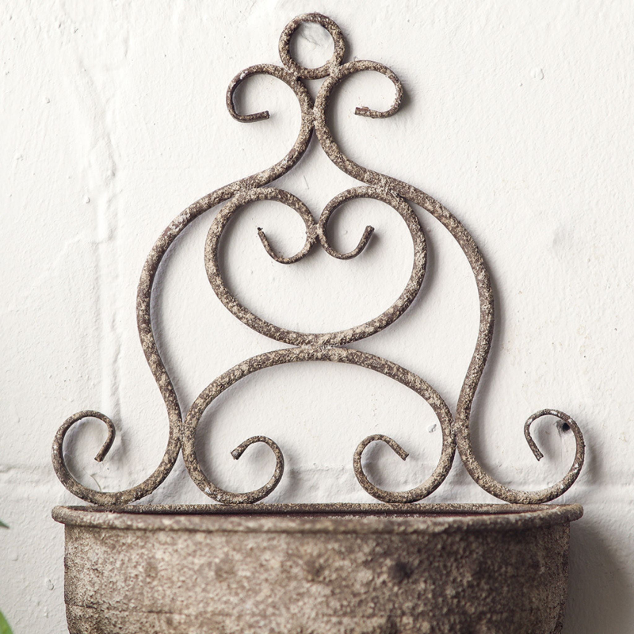Close-up of the scrolled metal back of the Claire wall planter