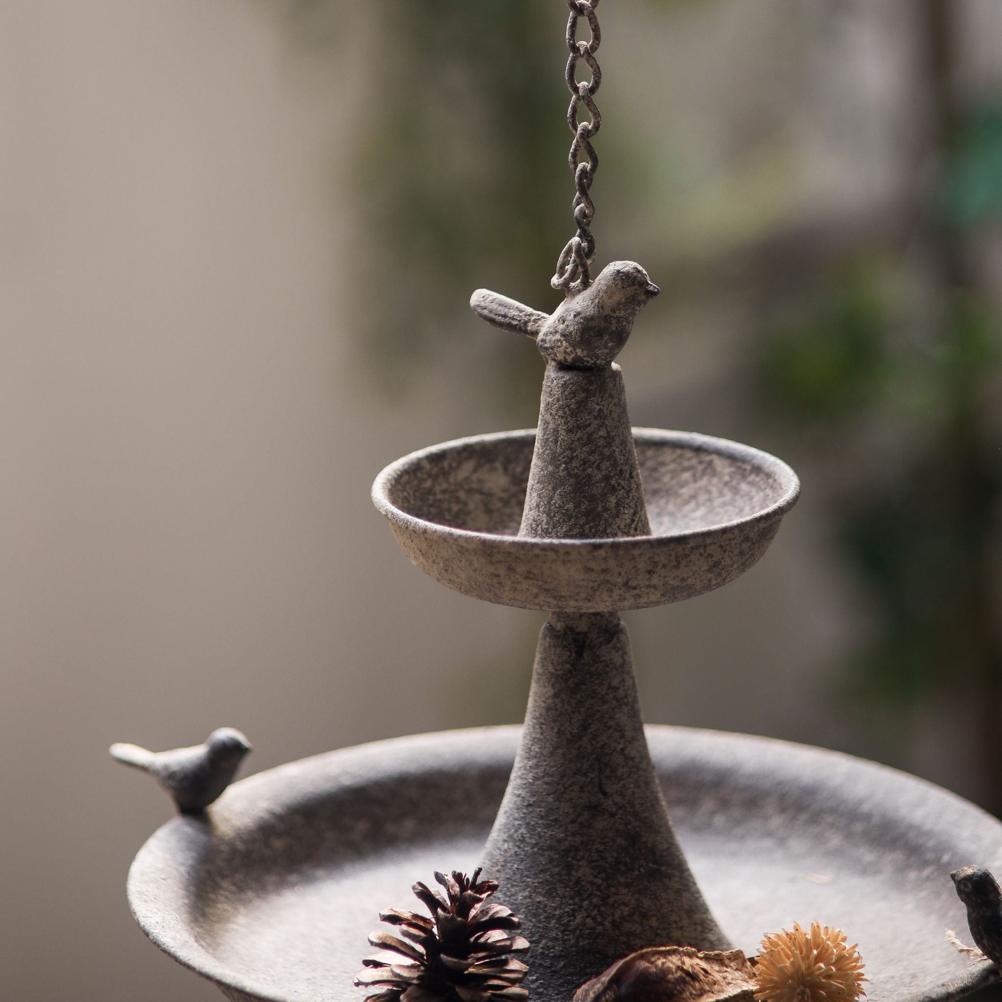 Close-up of the little bird finial on top of the Penelope two-tier feeder.