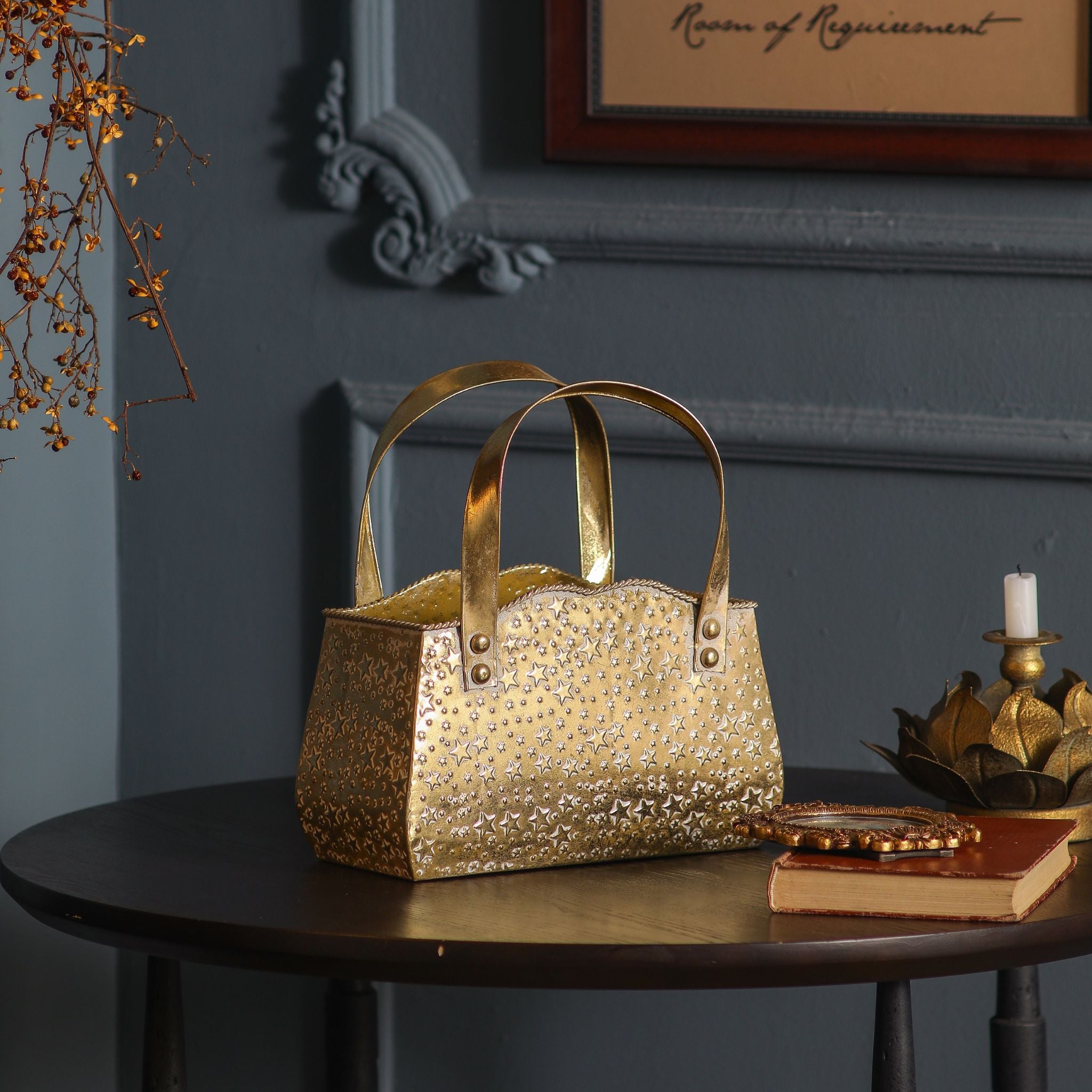 Antique gold star-embossed handbag planter on a dark side table in a moody French Provincial setting